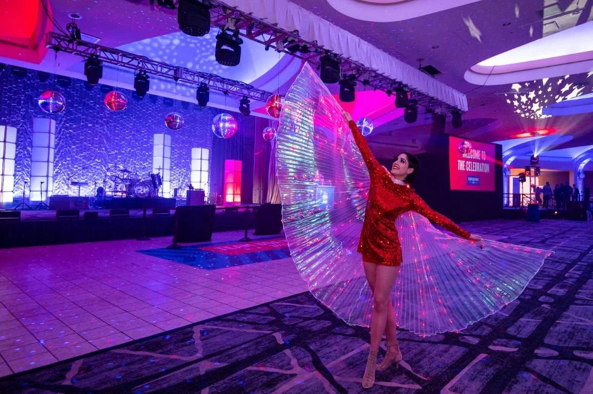 LED winged dancer costumed in a red sequin dress performing at an event for the United States Olympic Team in Washington, DC