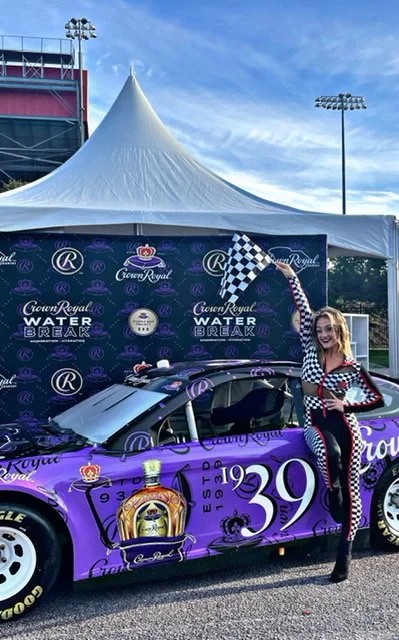 Race Car Girl Performer with Flag and Branded Purple Car