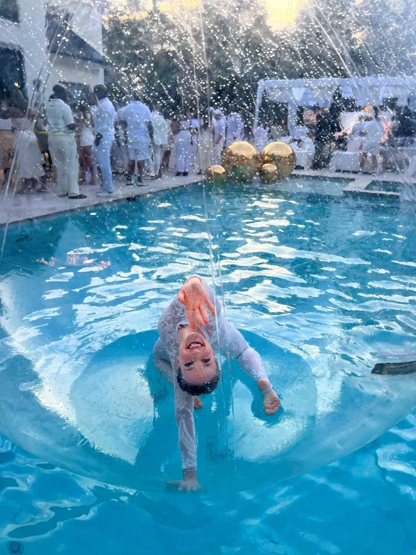 Bubble Girl in White Costume Reaching Back in Backbend Pose