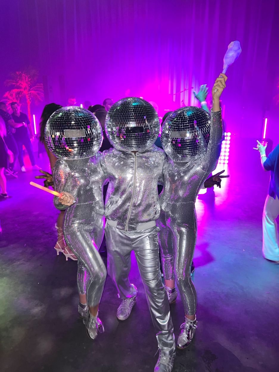 Trio of Disco Ball Dancers in Purple Lighting at a Late-Night Event