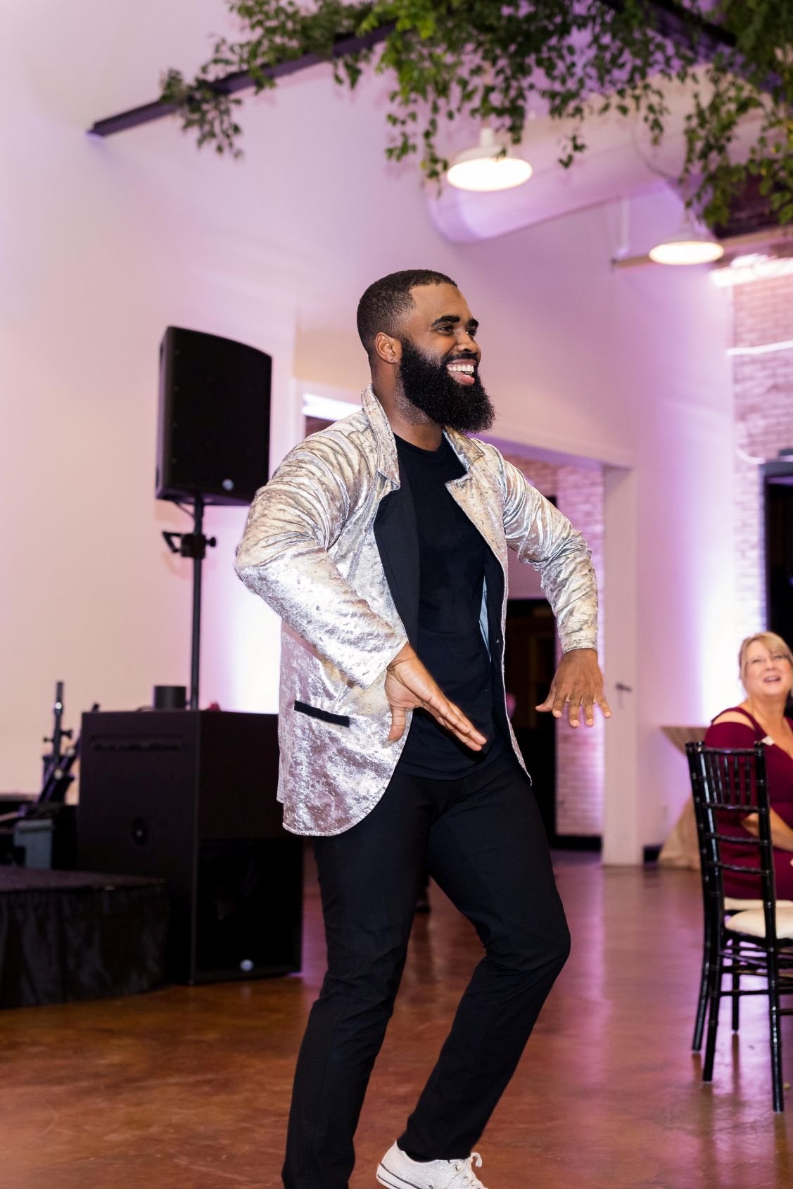 Male Go-Go Dancer in Silver Jacket Performing in a Ballroom