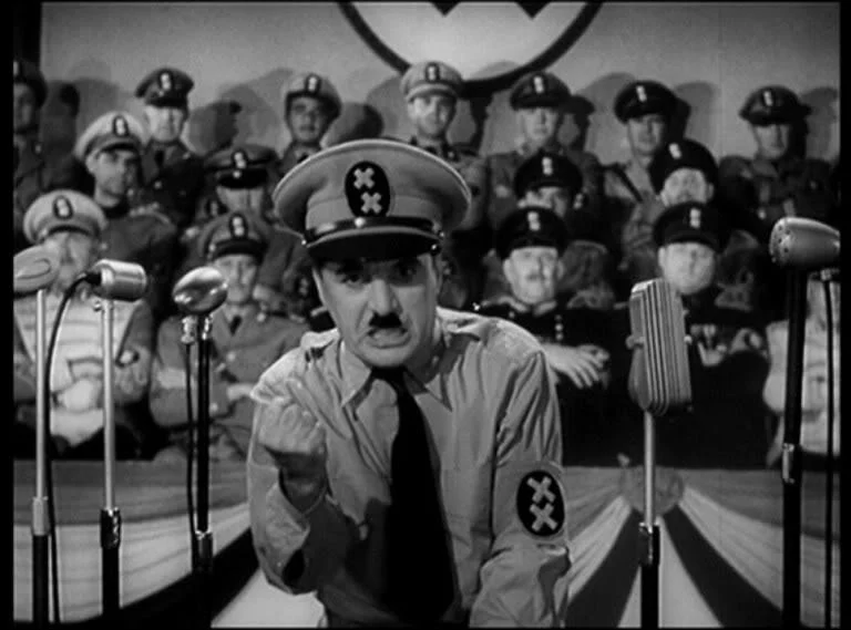 Chaplin, as Hynkel, bursts loudly into frame.