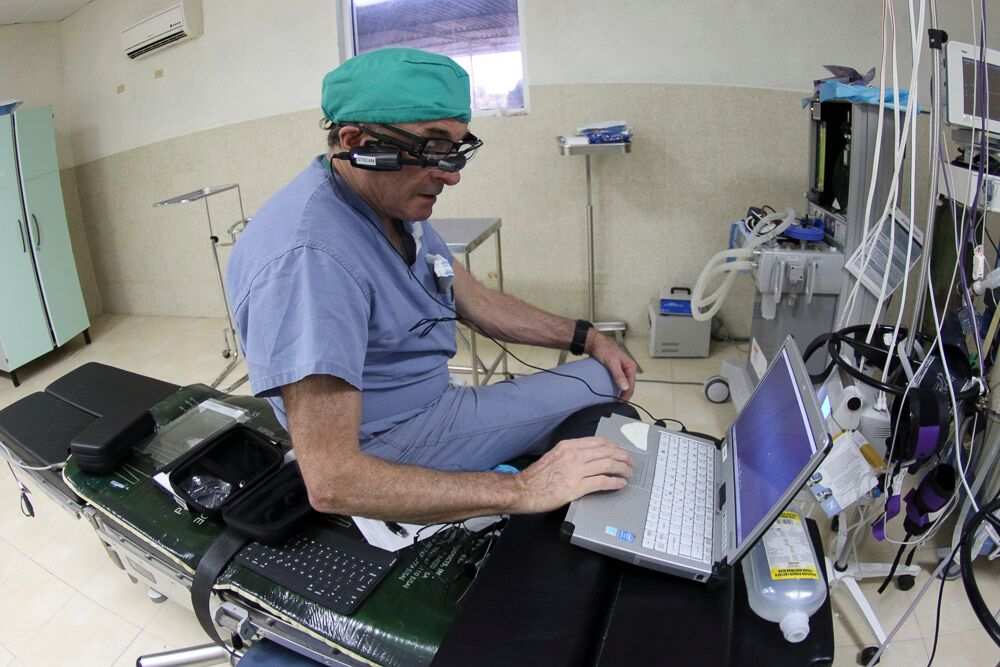 A medical volunteer consults his laptop