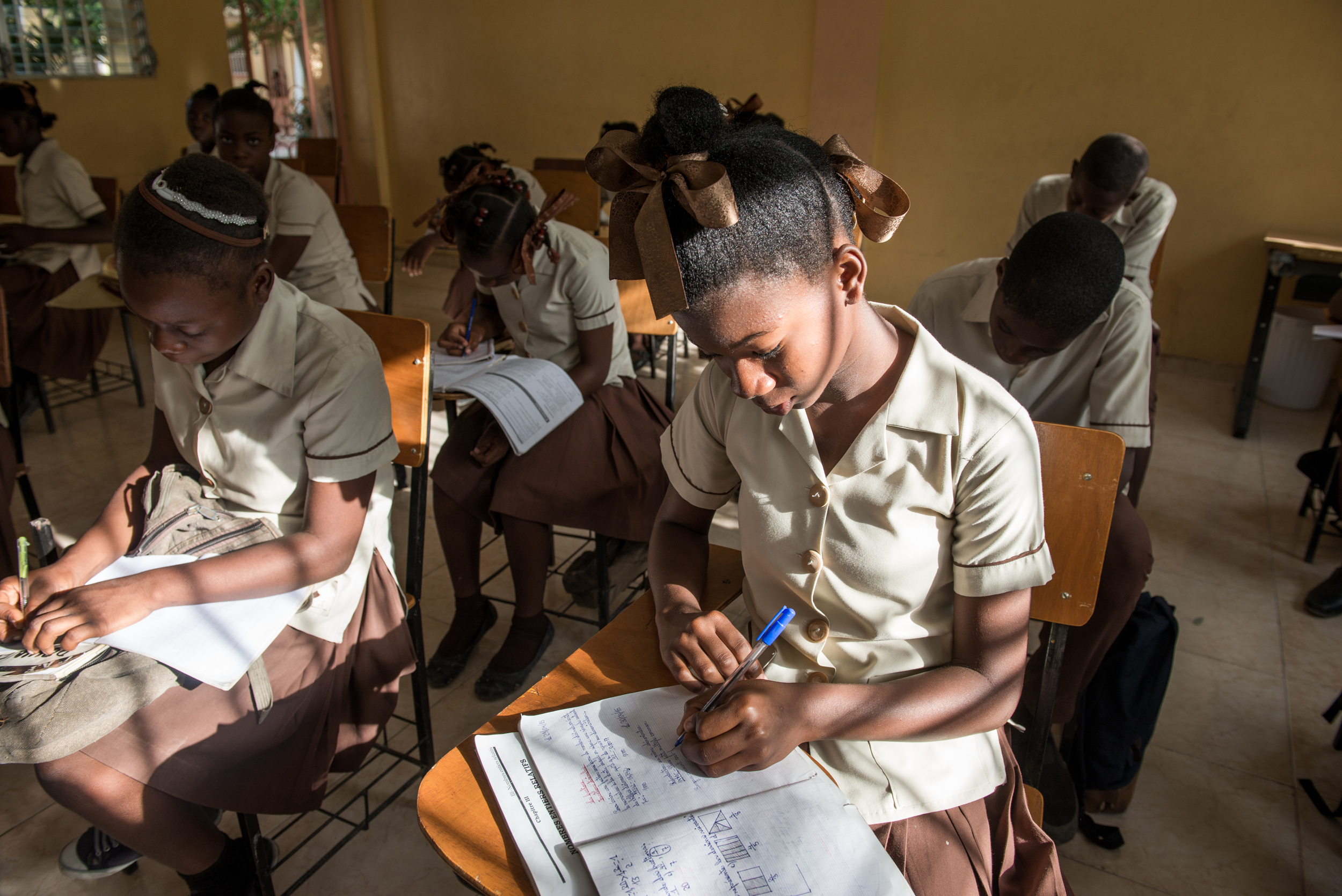 A girl takes notes during class at the Academy for Peace and Justice