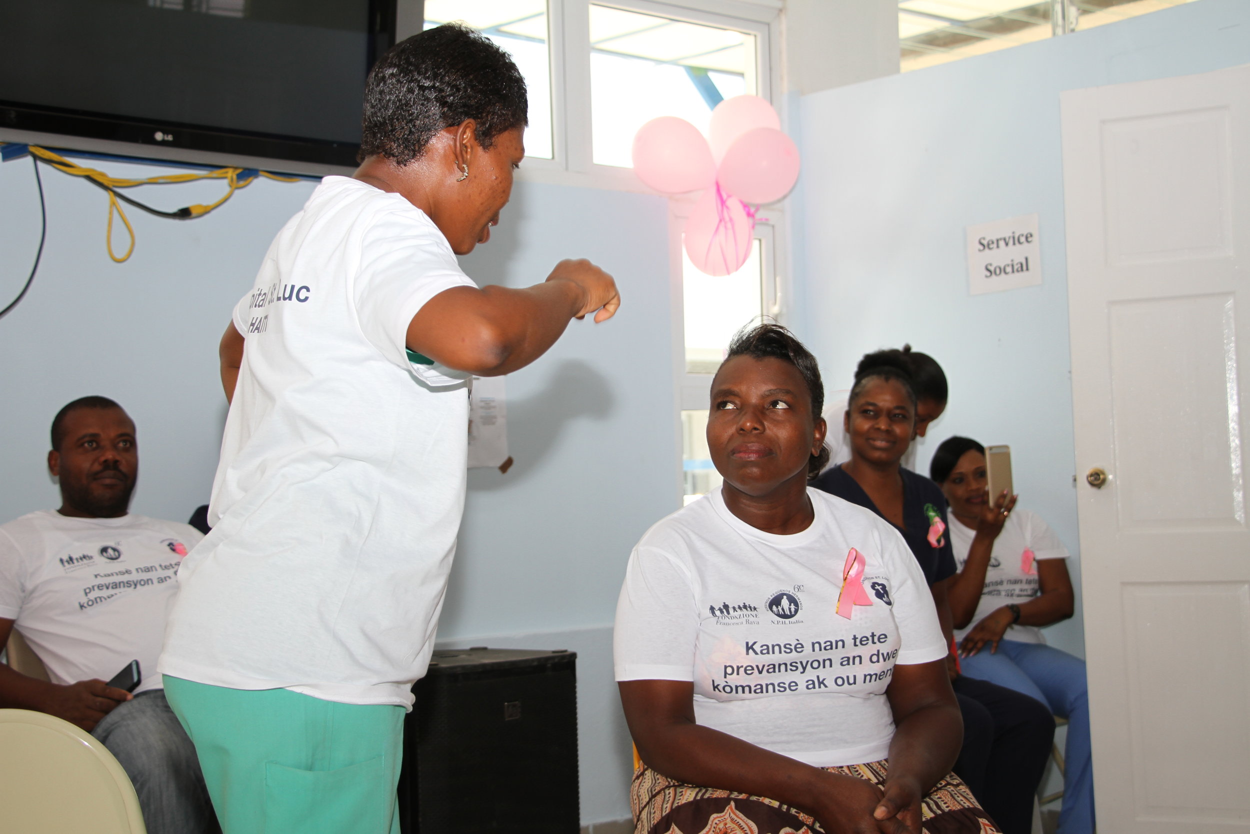 Yolette Senat (center) participates in an educational skit at a breast cancer screening event at St. Luke Hospital. 