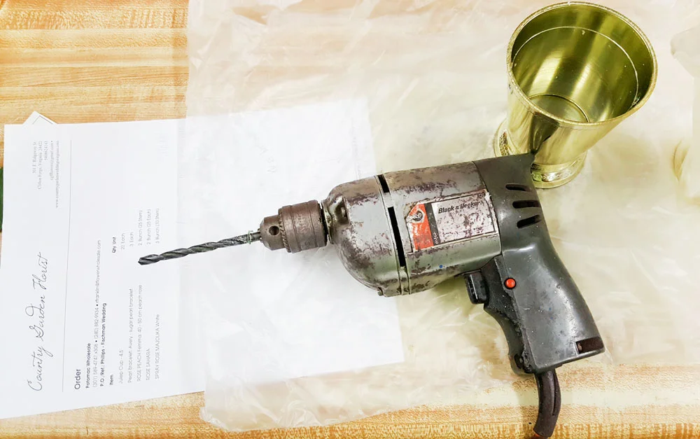 Using the trusty old drill that we inherited with the purchase of the shop, we simply drill two holes near the top and rear of the cup. Florists LOVE power tools! Ask anyone.