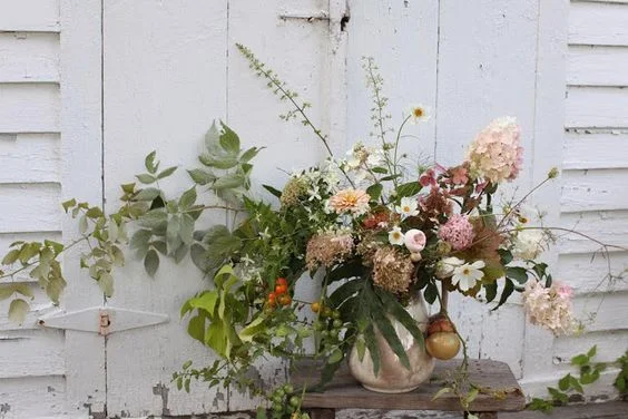 A wild and unruly arrangement fresh from the garden featuring cosmos, limelight hydrangea, raspberry foliage, zinnias. coral bells and yes, those are cherry tomatoes. 