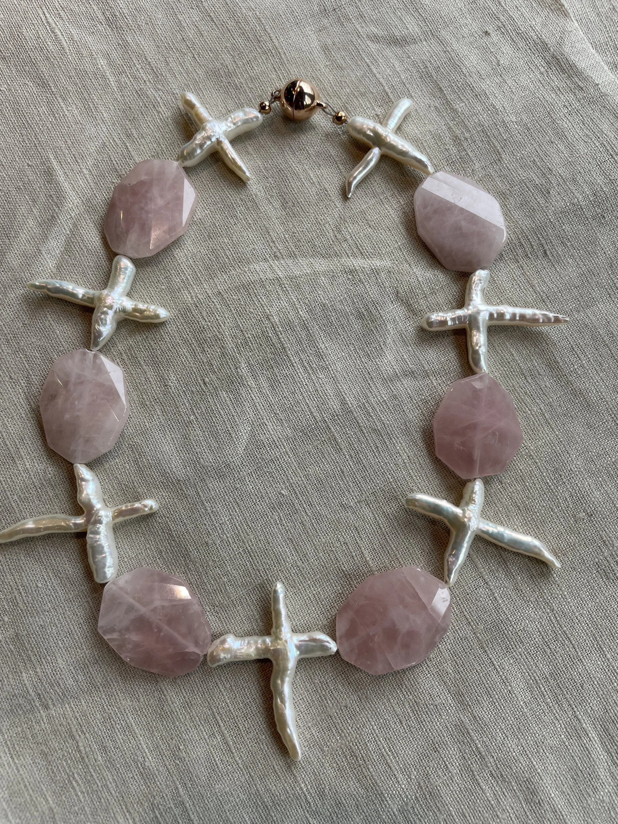 Rozenquartz ketting met parelmoer kruizen.