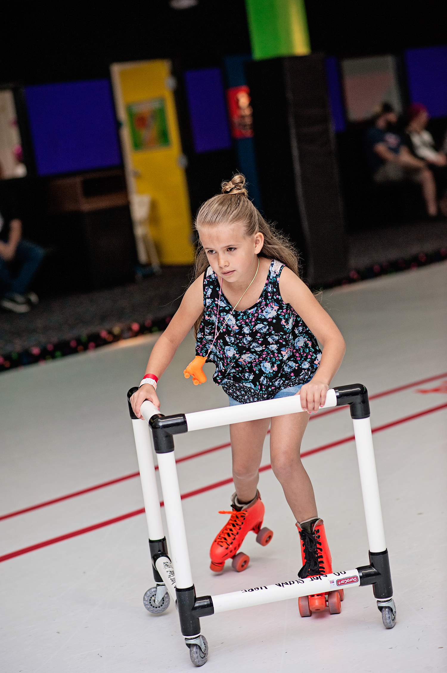  Concentrated girl rollerskating with a skating aid 