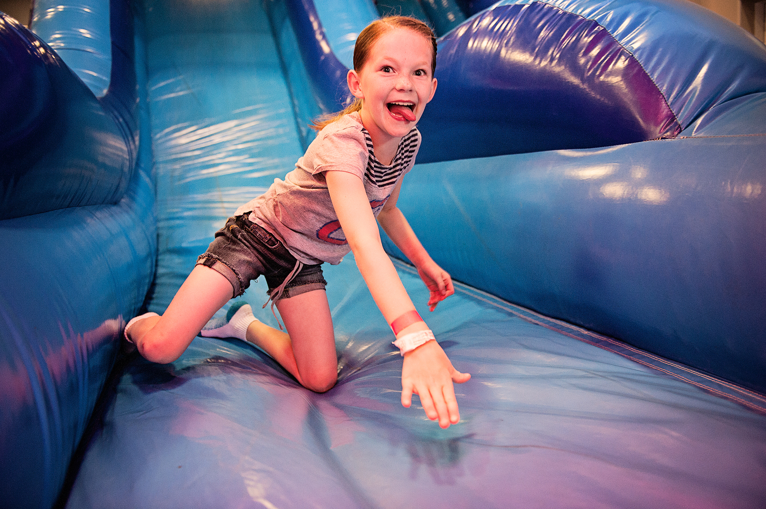  girl excitingly climbs up inflated slide at classic fun center 