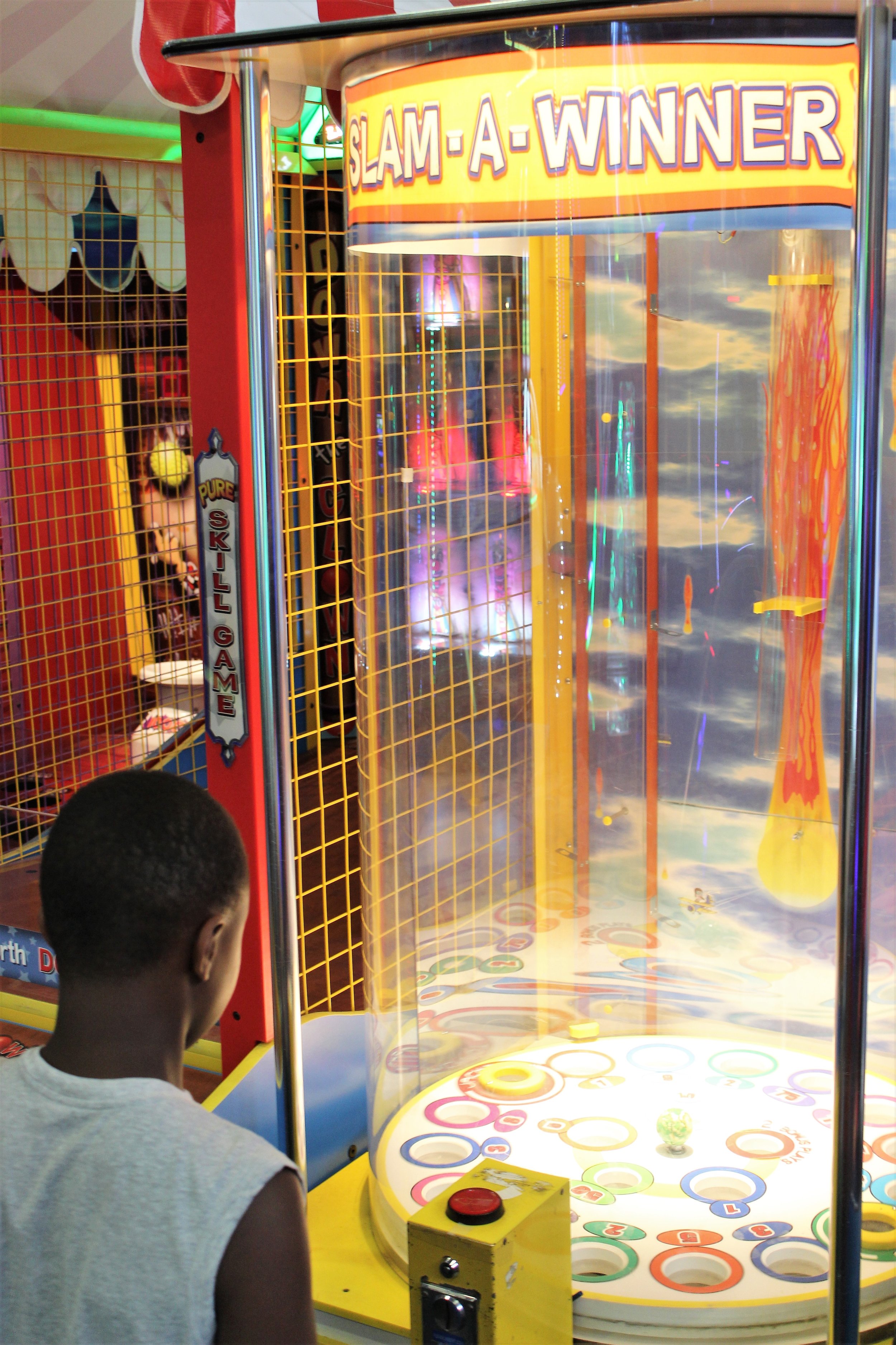  young boy playing slam-a-winner arcade game at classic fun center 