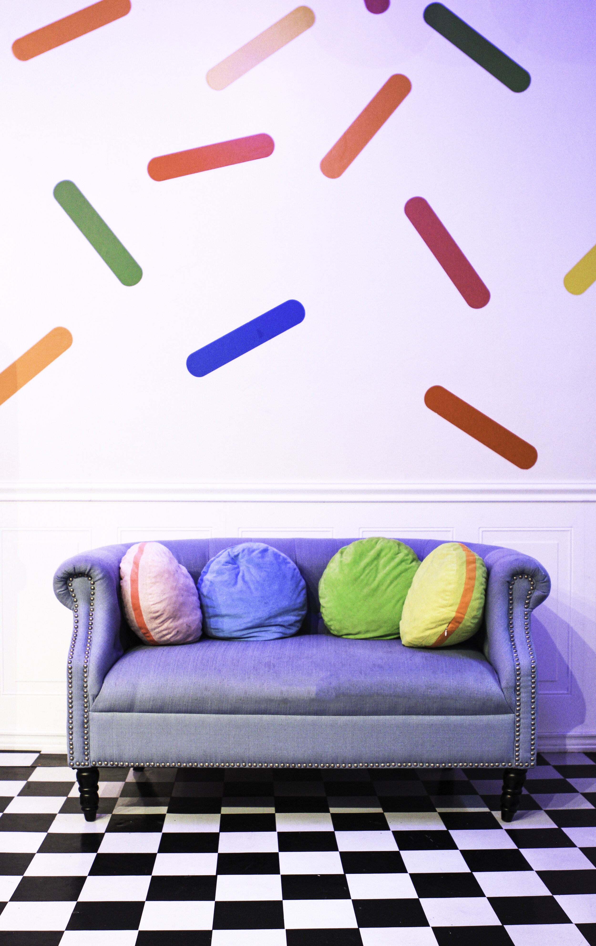  blue couch in front of a sweet sprinkle painted wall 