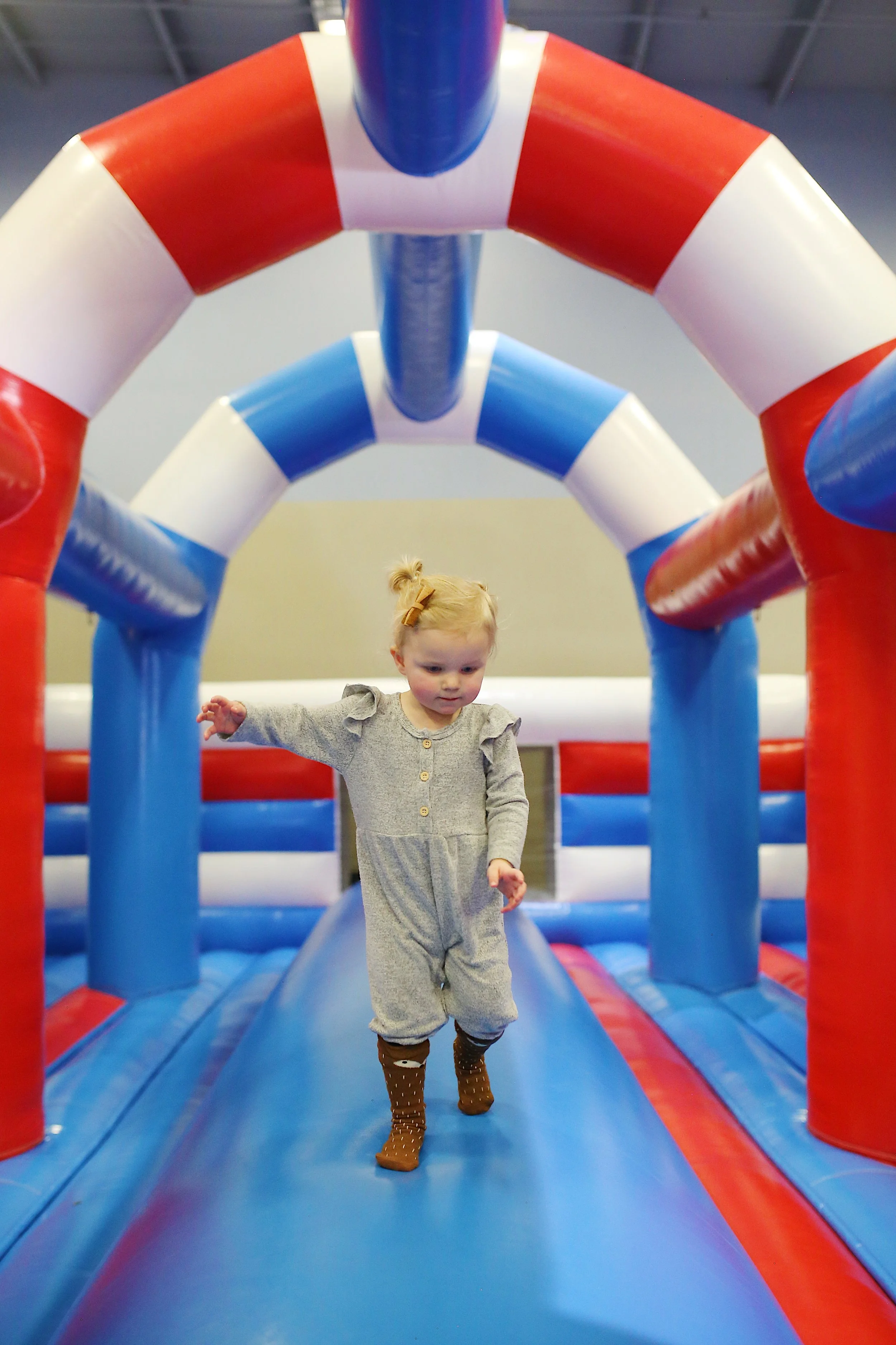  toddler walks across bouncy house balance beam 