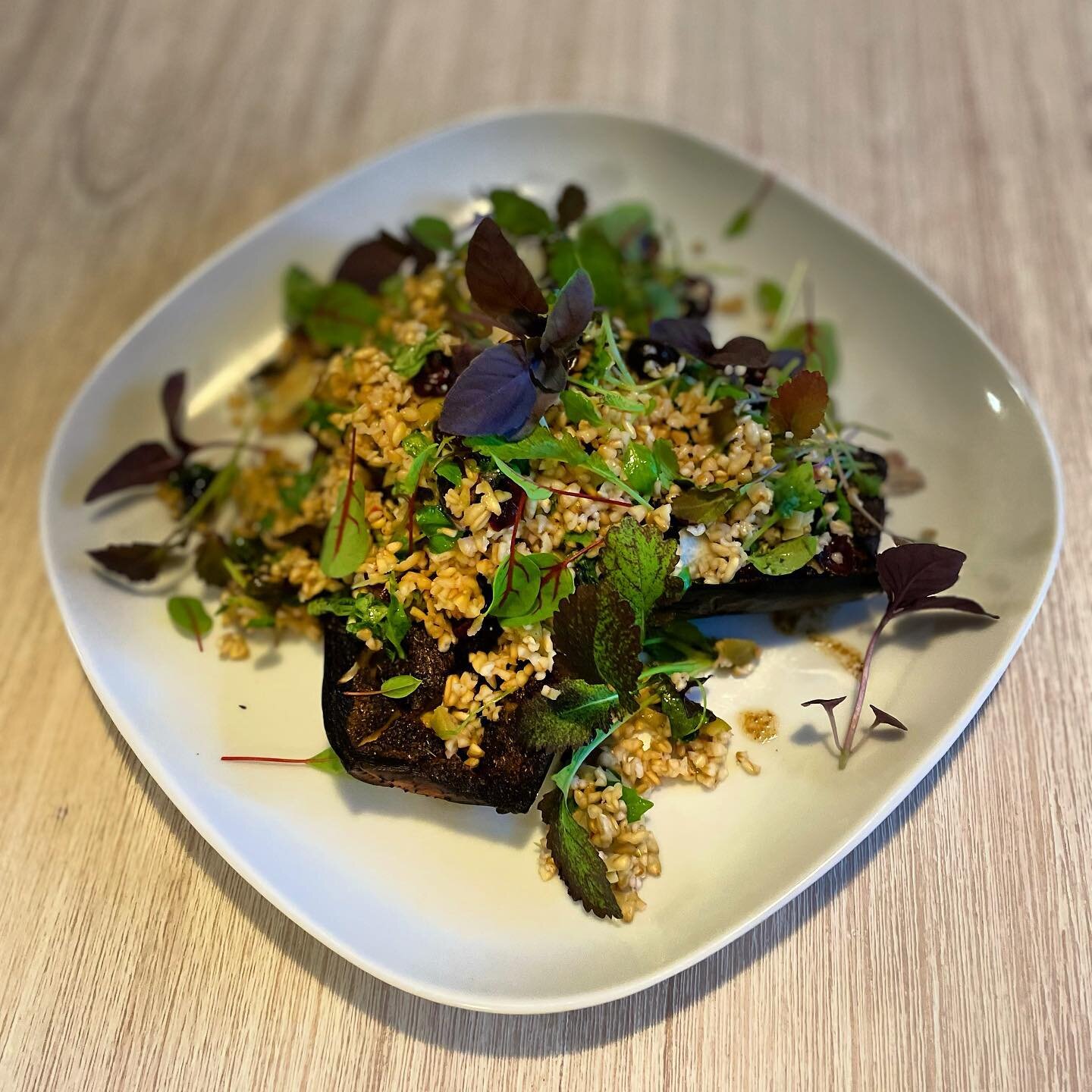 On the menu tonight! Roast eggplant with lazy chefs Ras el Hanout, served with a bulgur salad of raisins, shaved almond, green olives, preserved lemon, soft herbs  and finished with Purple and Genovese Basil, Red Sorrel and red mustard leaves 🍃 🍁 ?