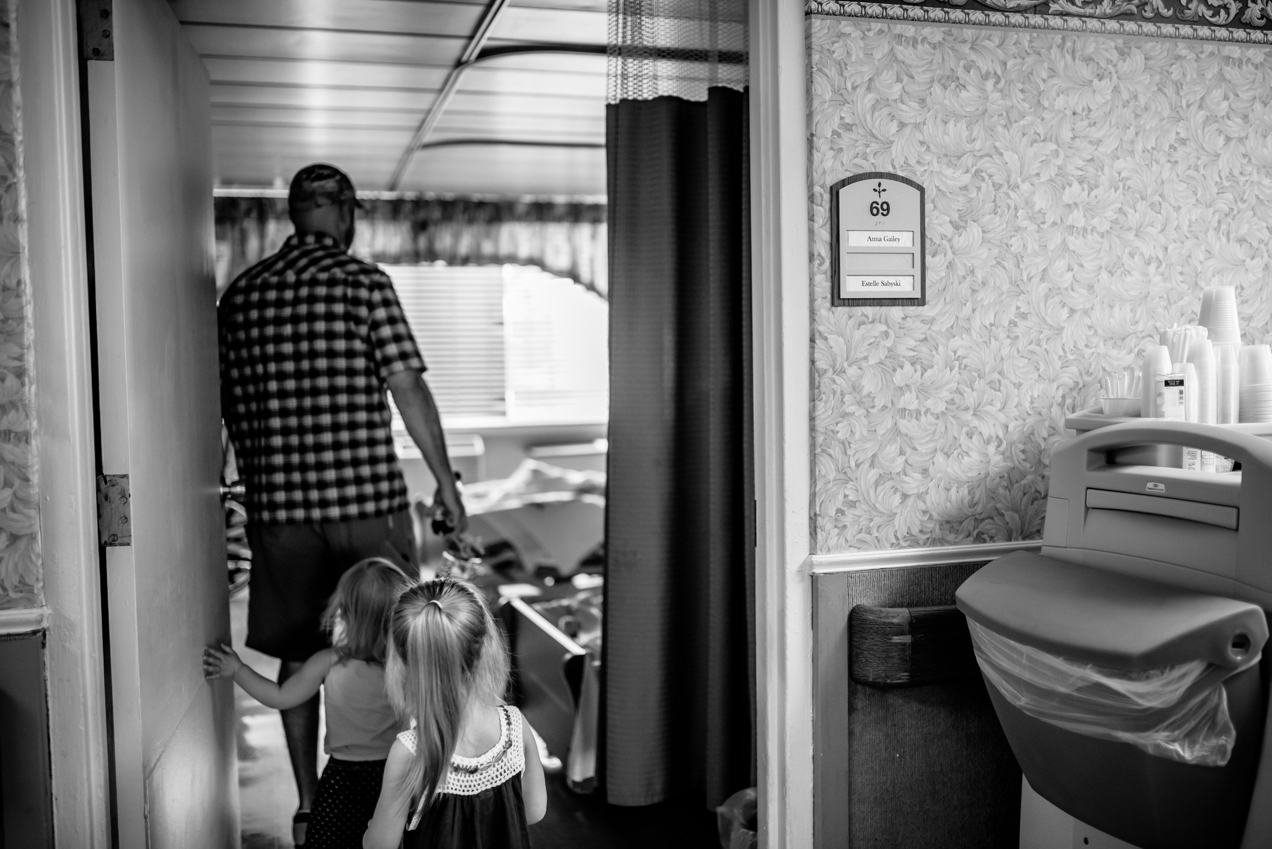 Dad and daughters entering room of nursing home