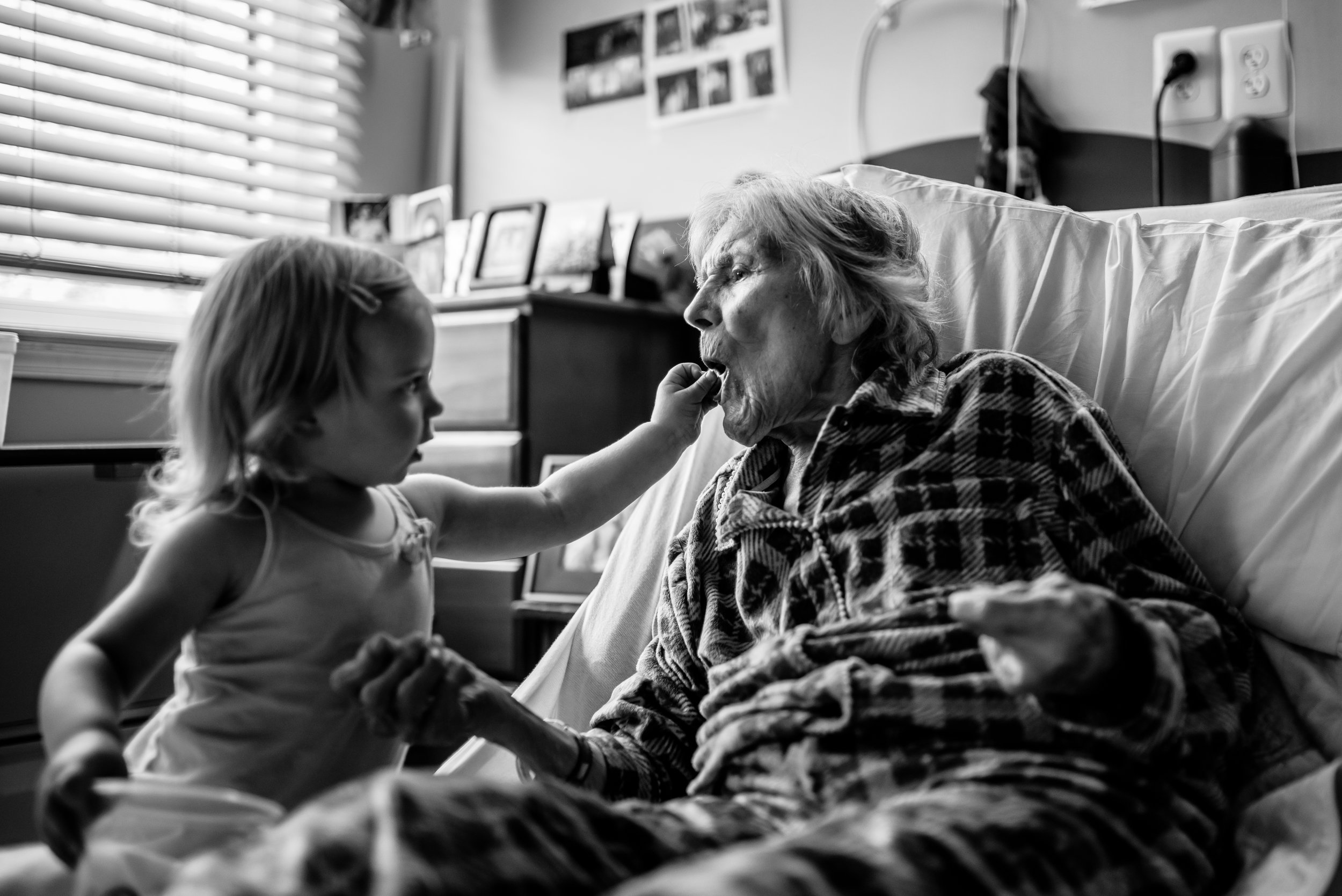 Girl feeds pretzel to great-great-grandmother