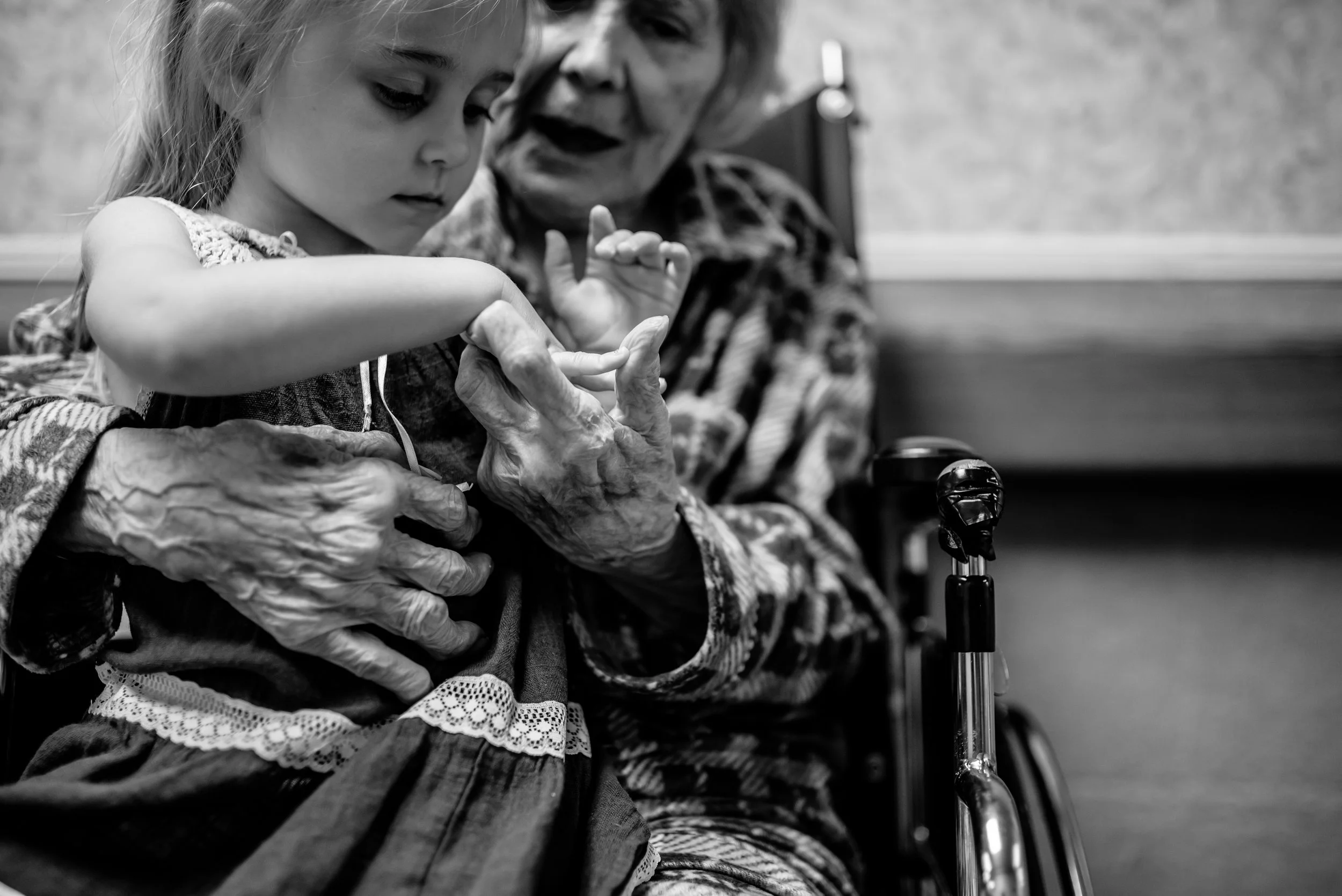 girl touches great-great-grandmother's hand