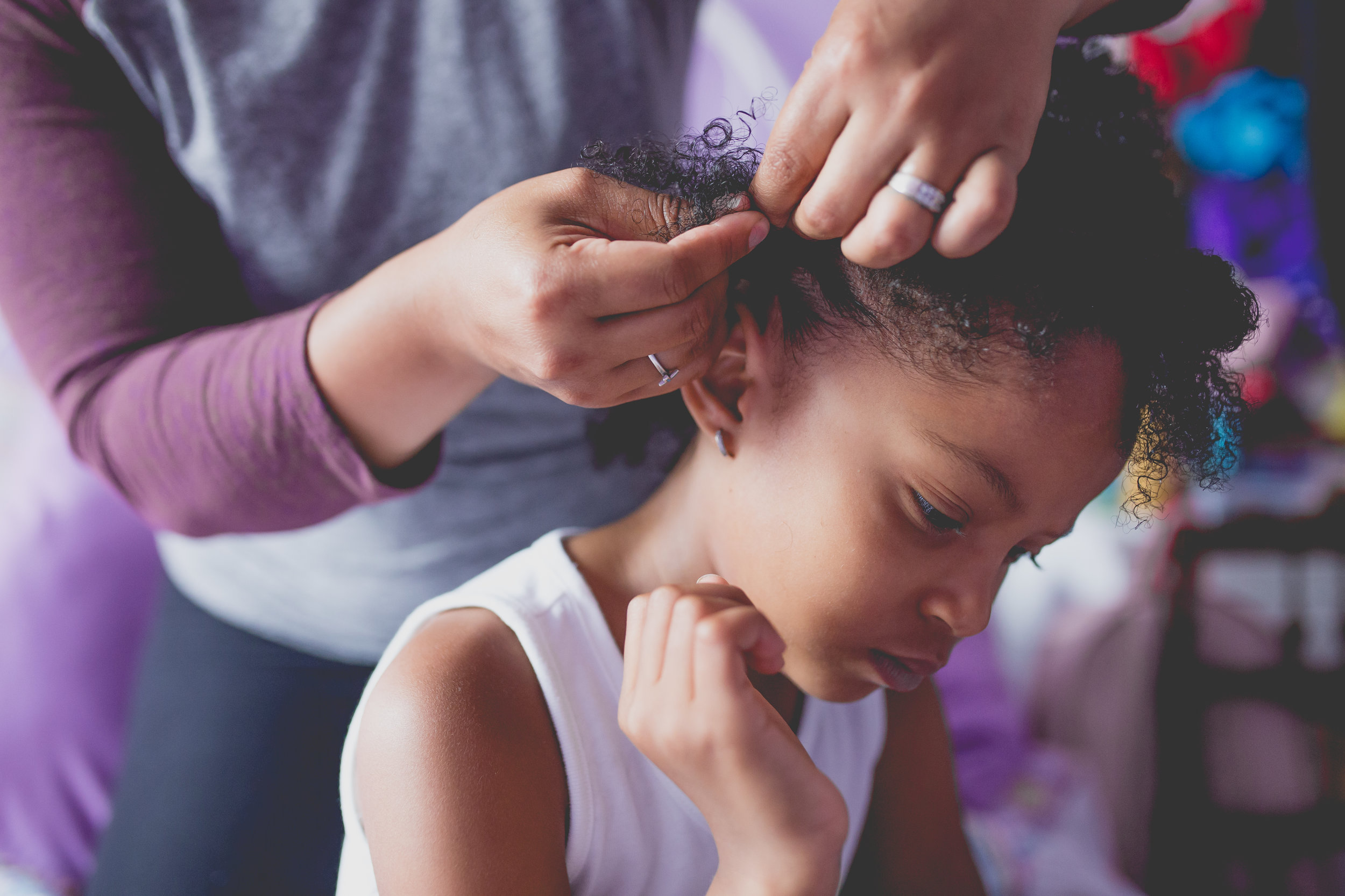 Mom puts cornrow in daughter's hair