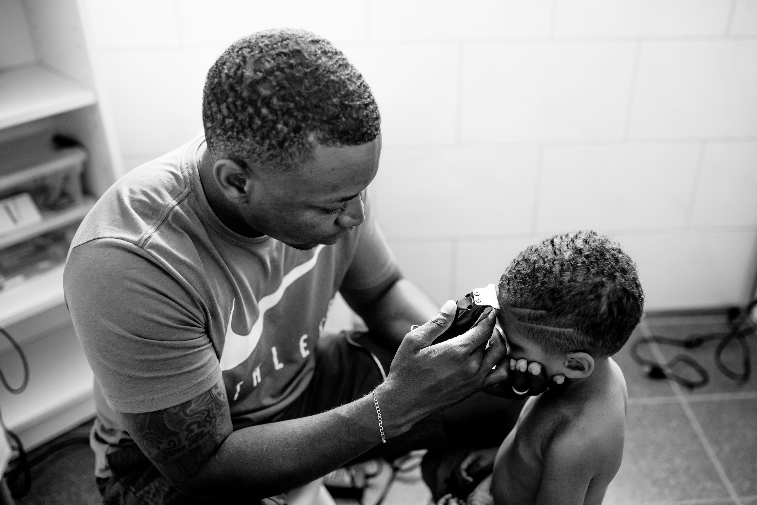 Dad cuts front of son's hair