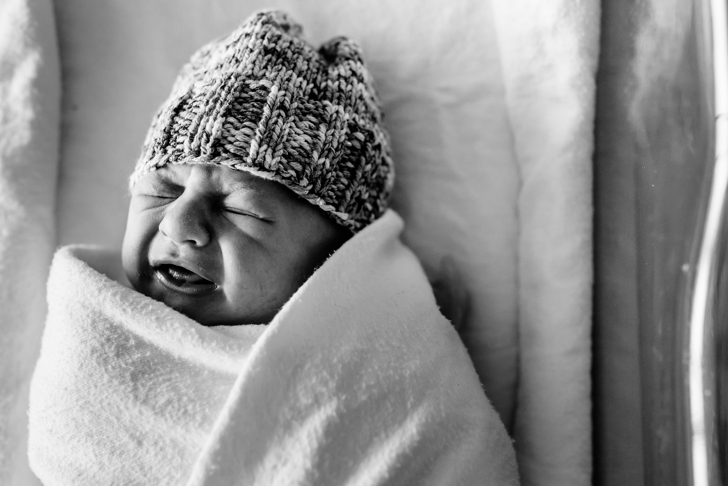 Newborn crying in hospital bassinet
