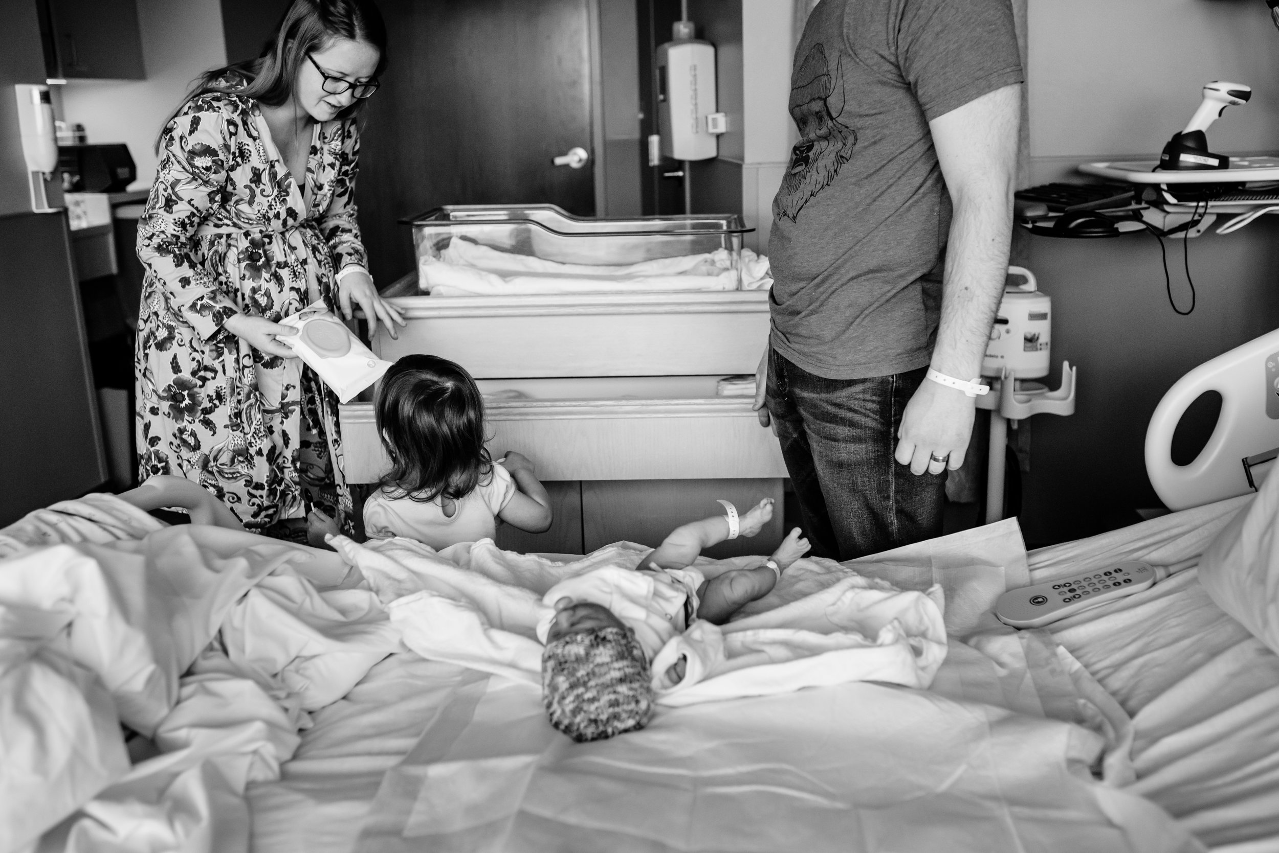 Girl helps parents change newborn brother's diaper
