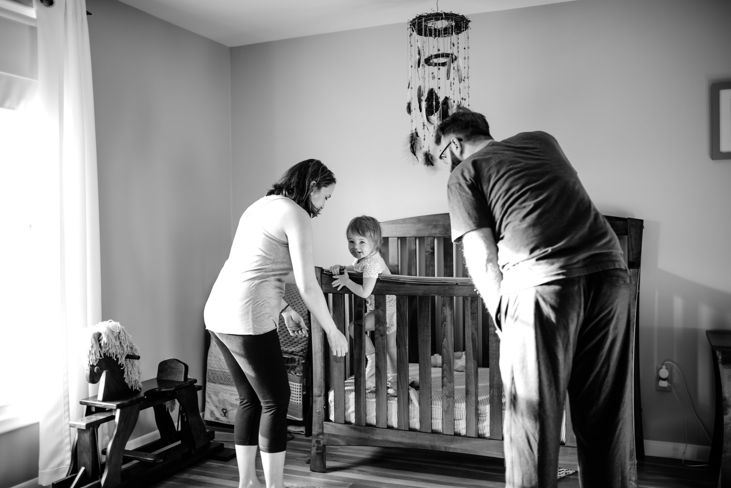 Mom and Dad greet baby in crib