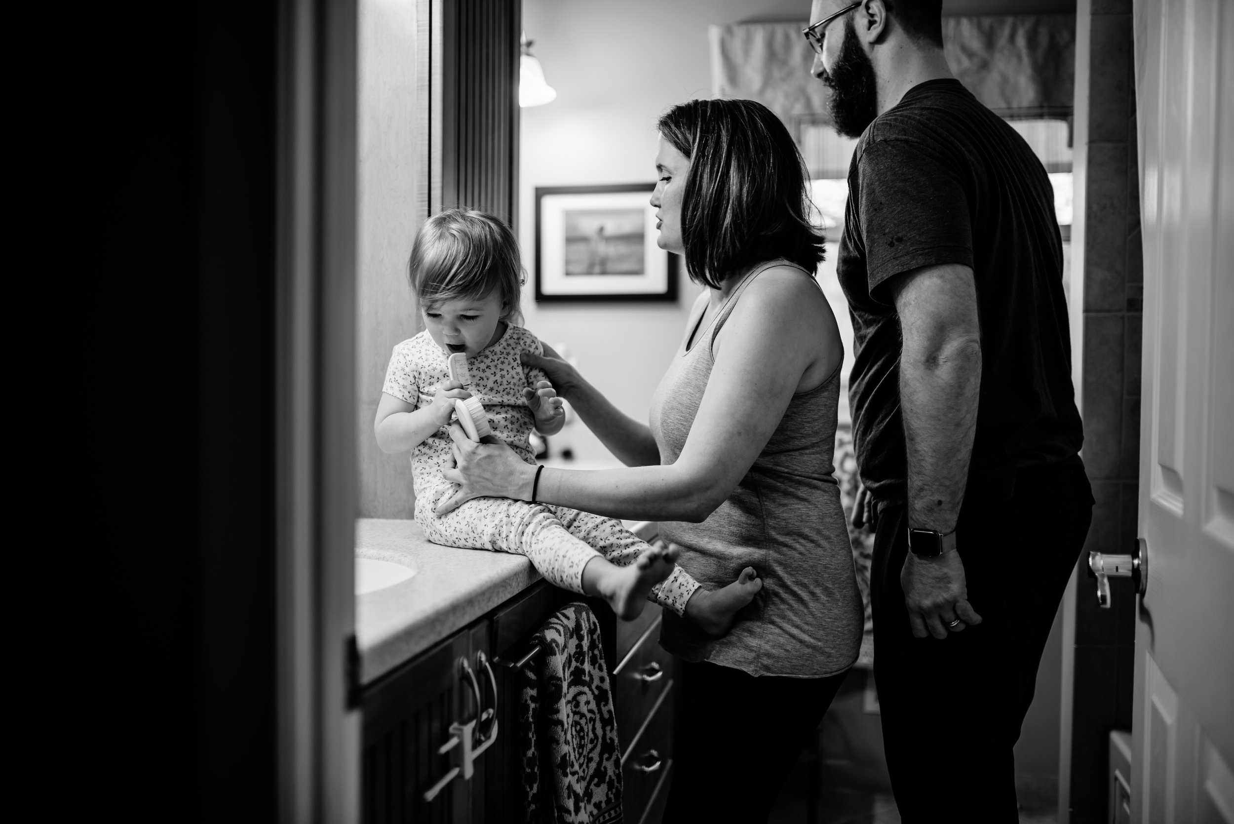 Mom and Dad get daughter ready for the day in bathroom