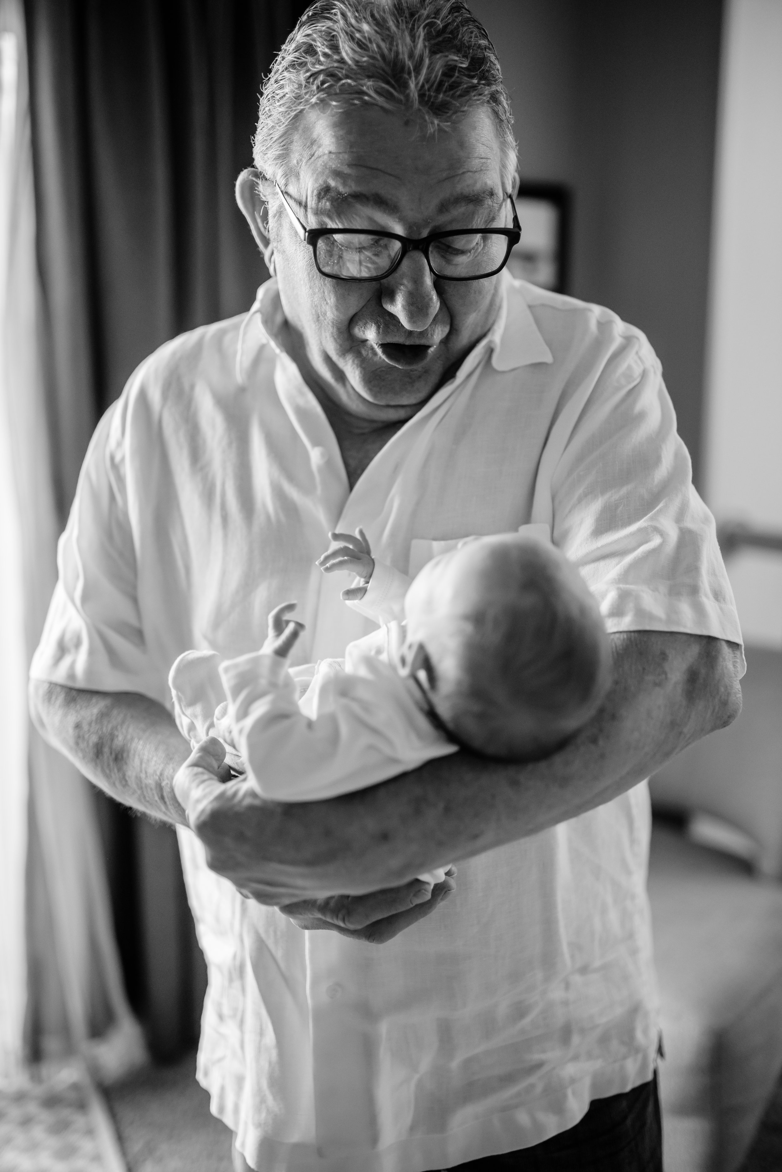 Grandpa talks to newborn baby he is holding