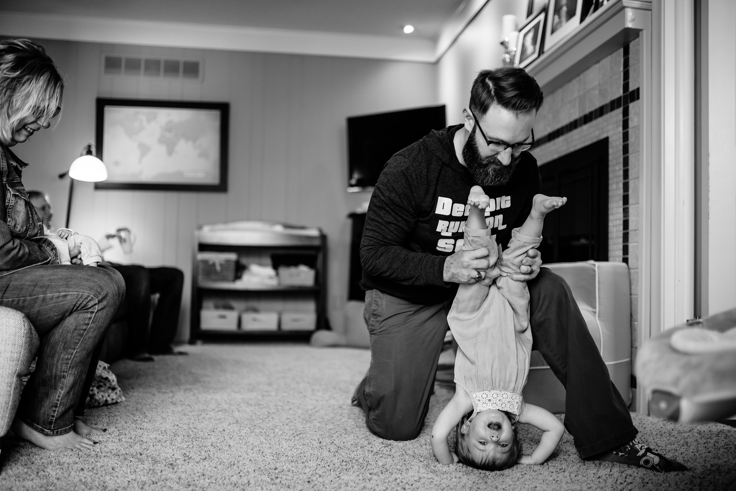 Dad plays with daughter and holds her upside-down