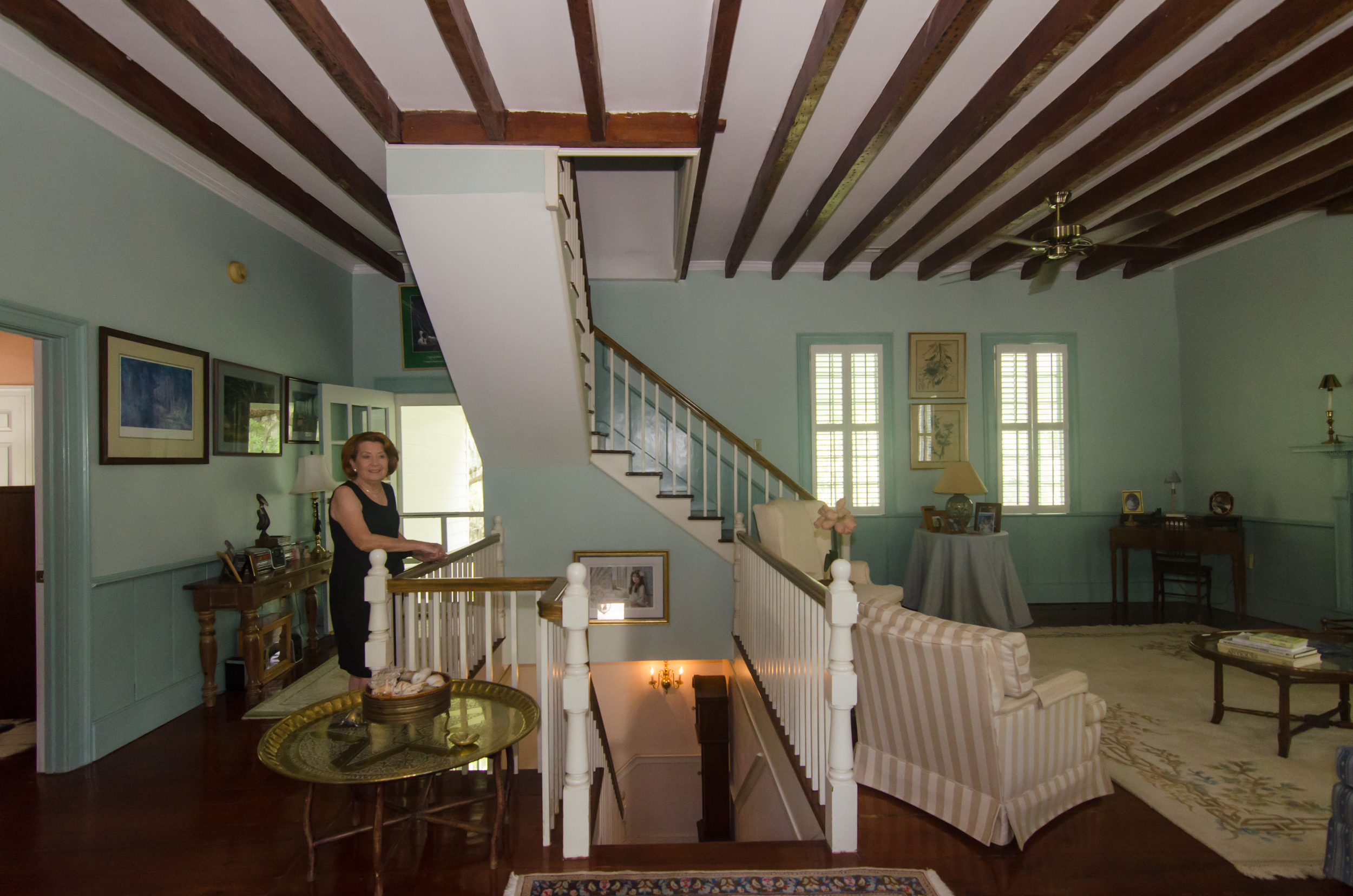 Brenda leans by the railing next to their upstairs living area.