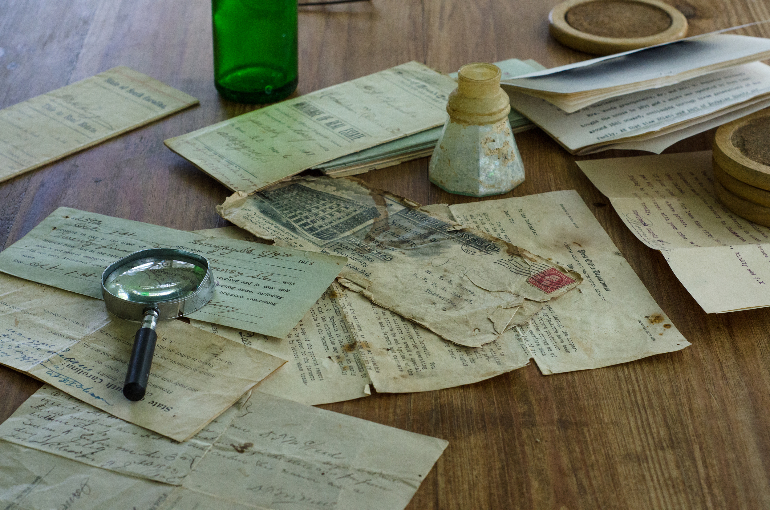 Old letters, notes and deeds with a magnifying glass.
