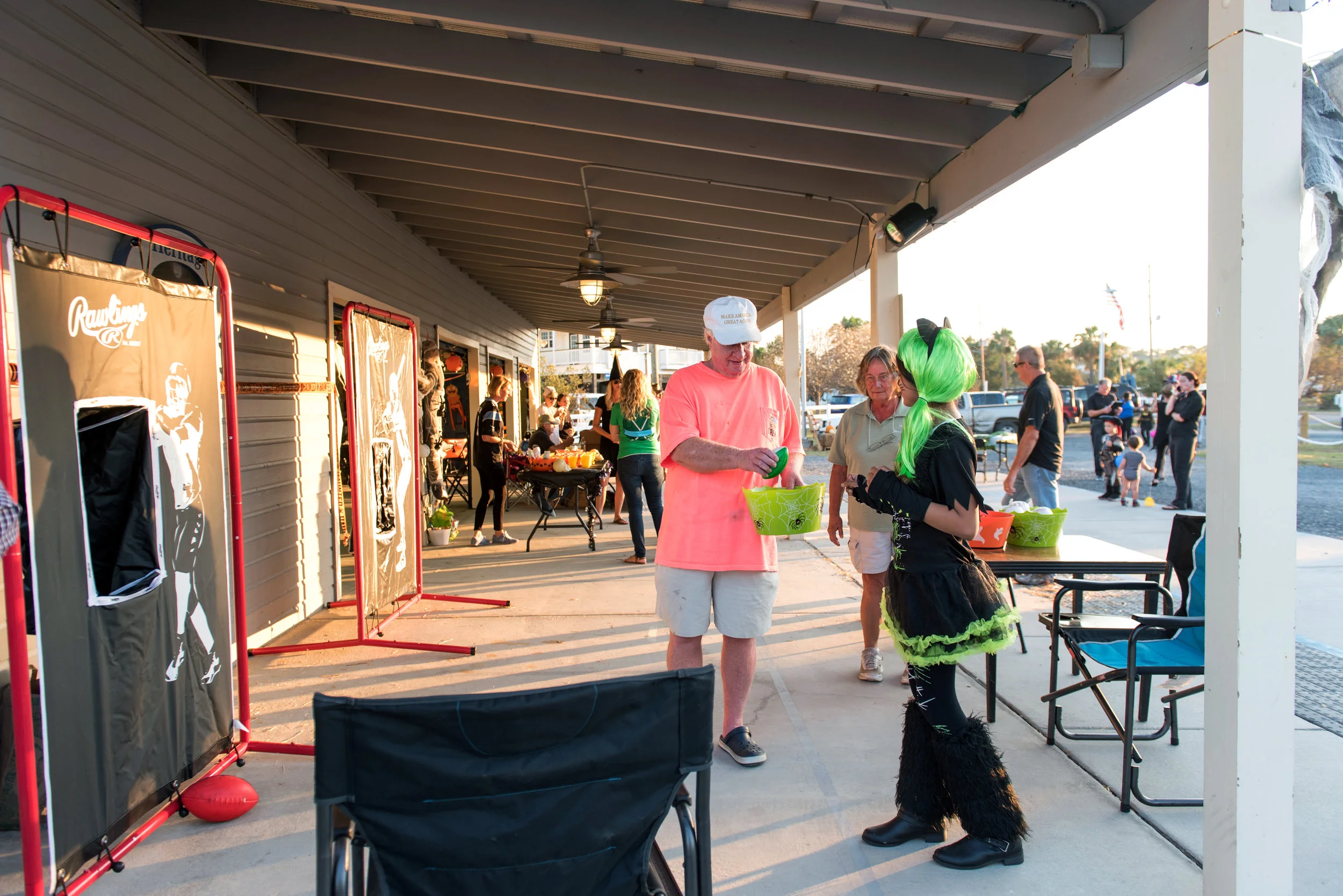 Woman in green wig passes out candy at Halloween Festival.