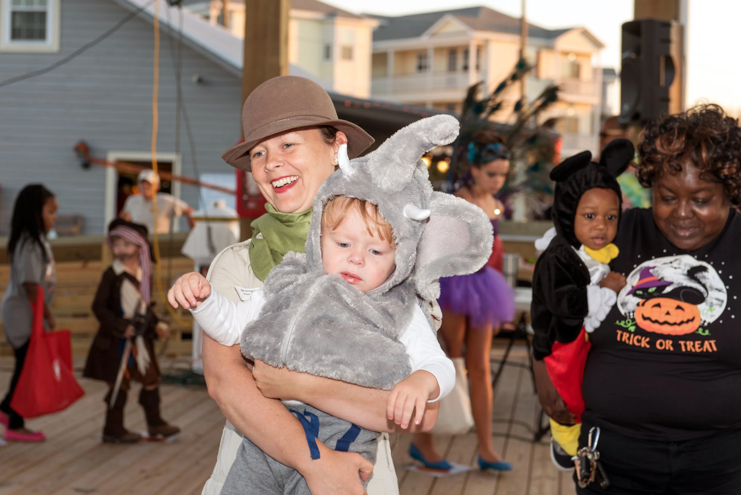 Mother and child dressed as safari guide and elephant participate in cake walk at Halloween festival.