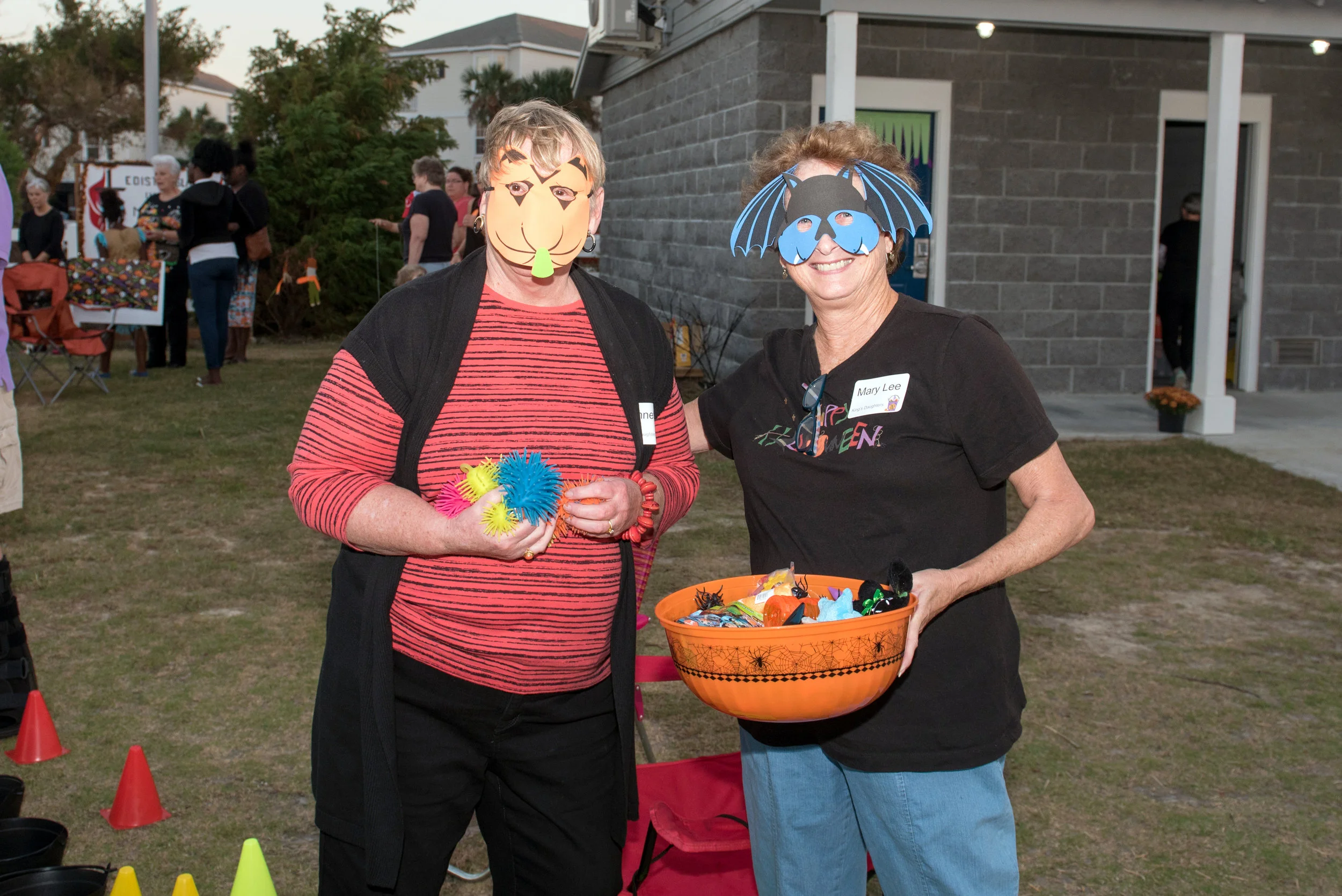 Two adults in Halloween costumes pose for camera.