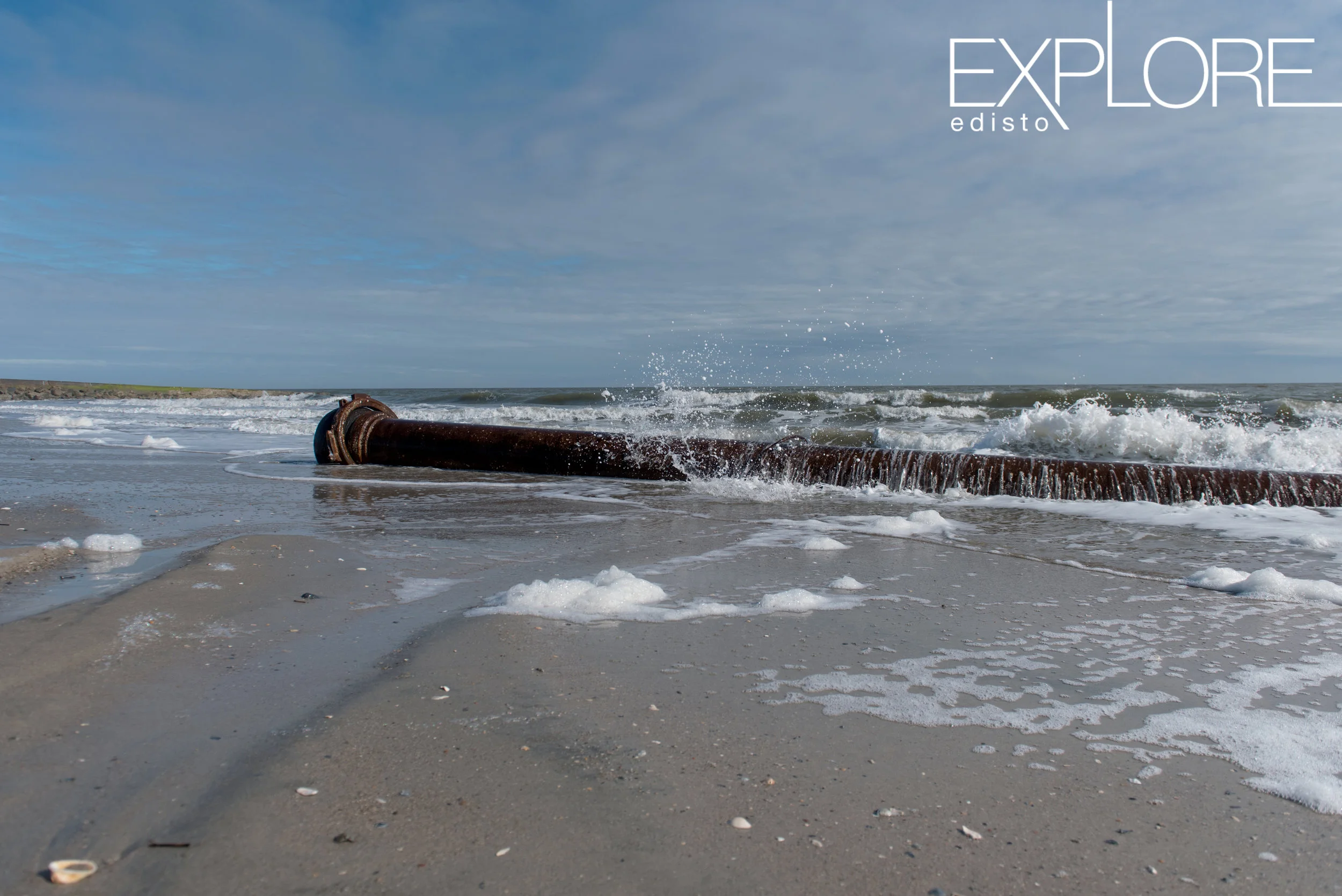 Water splashing against pipe in ocean for beach nourishment.