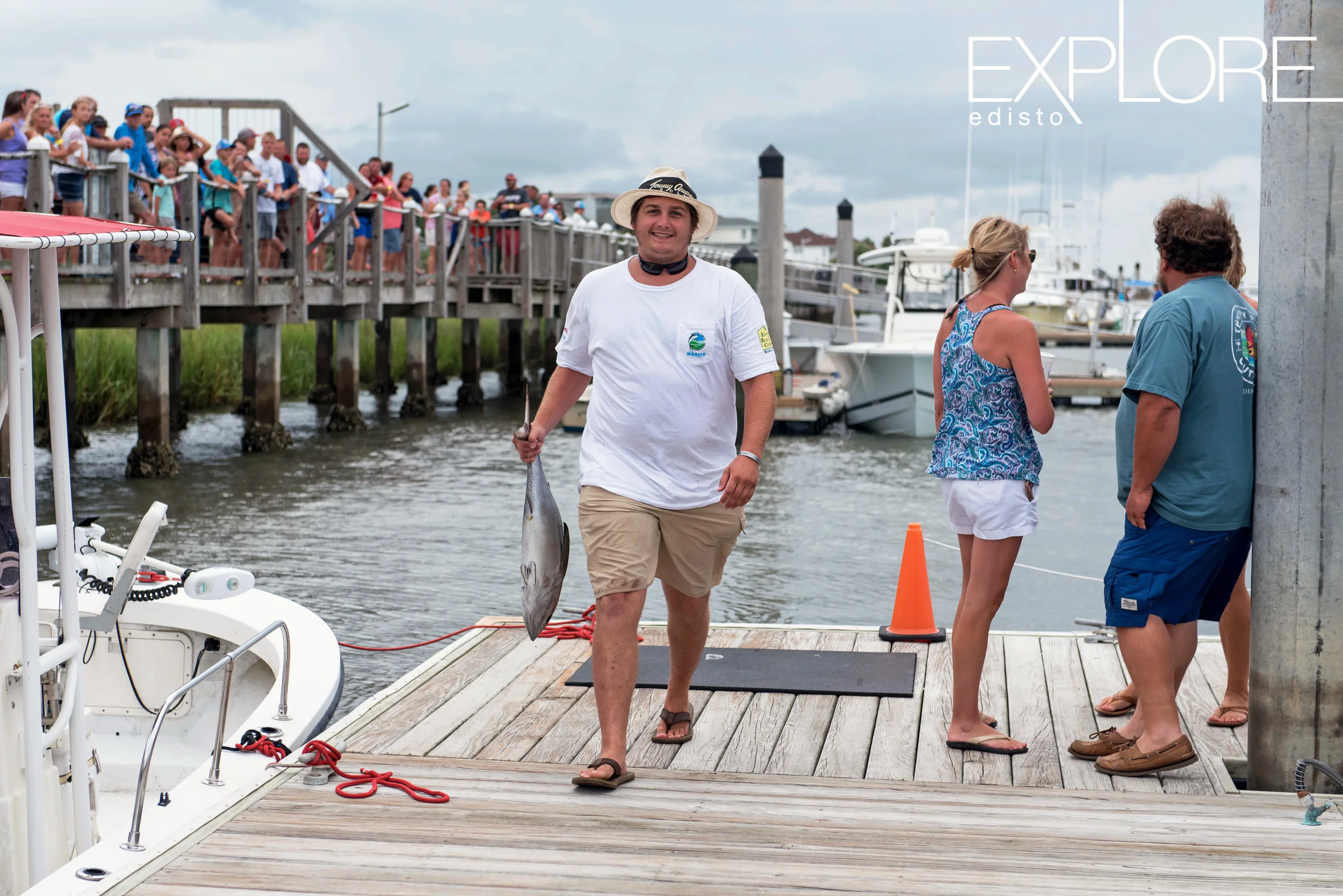 Proud fisherman carries Tuna on dock to be weighed in.