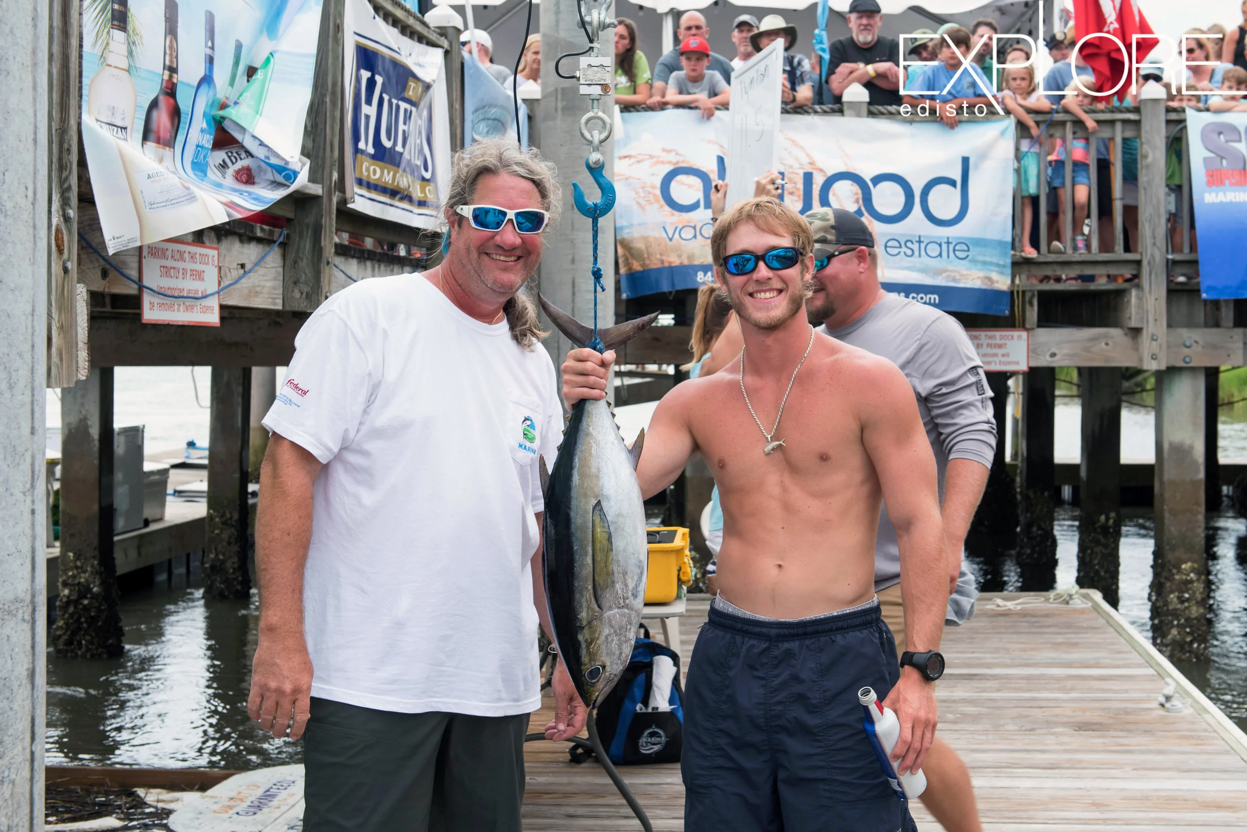 Men in sunglasses pose with Tuna fish at weigh-in.