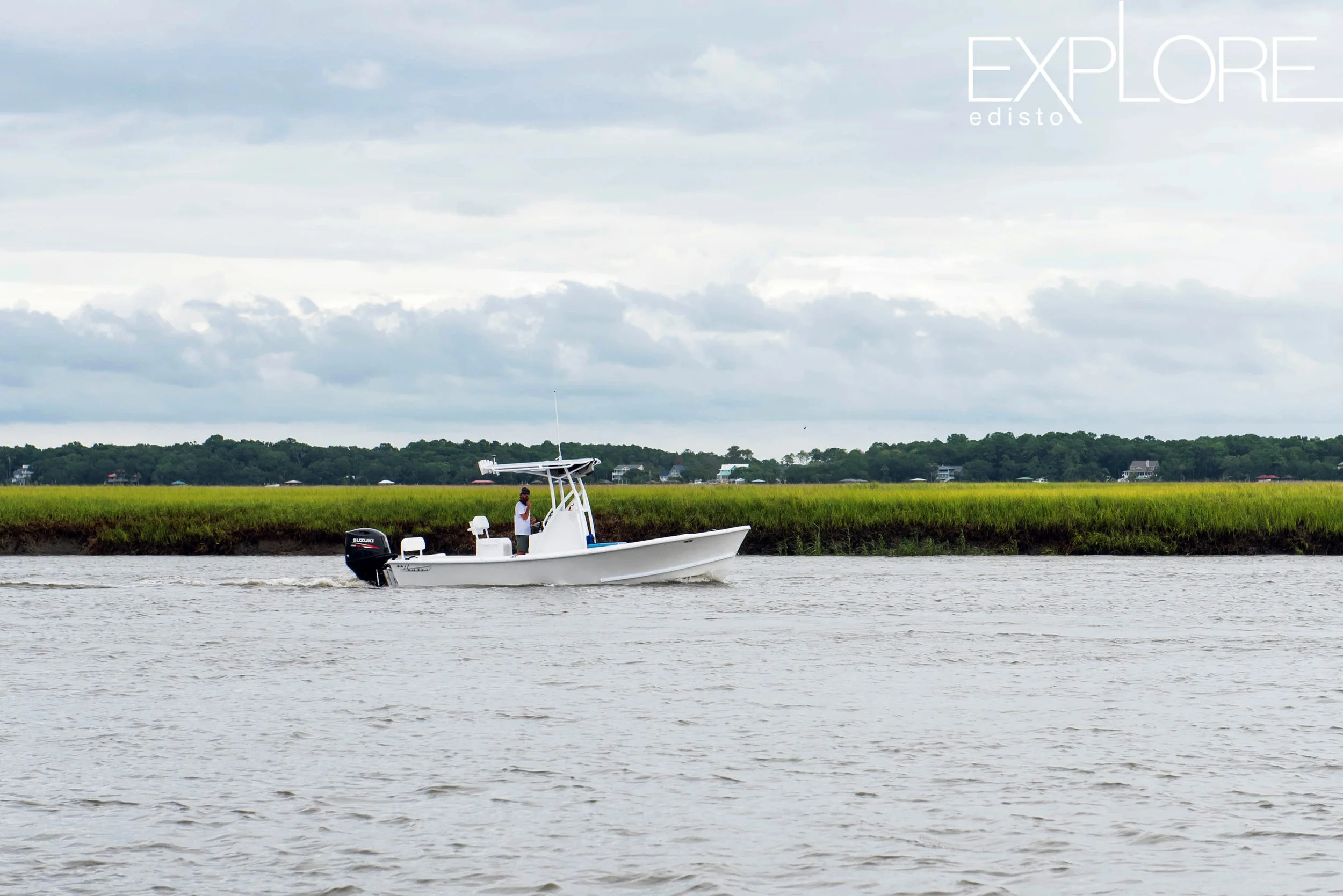 Boat in the creek with marsh in background.
