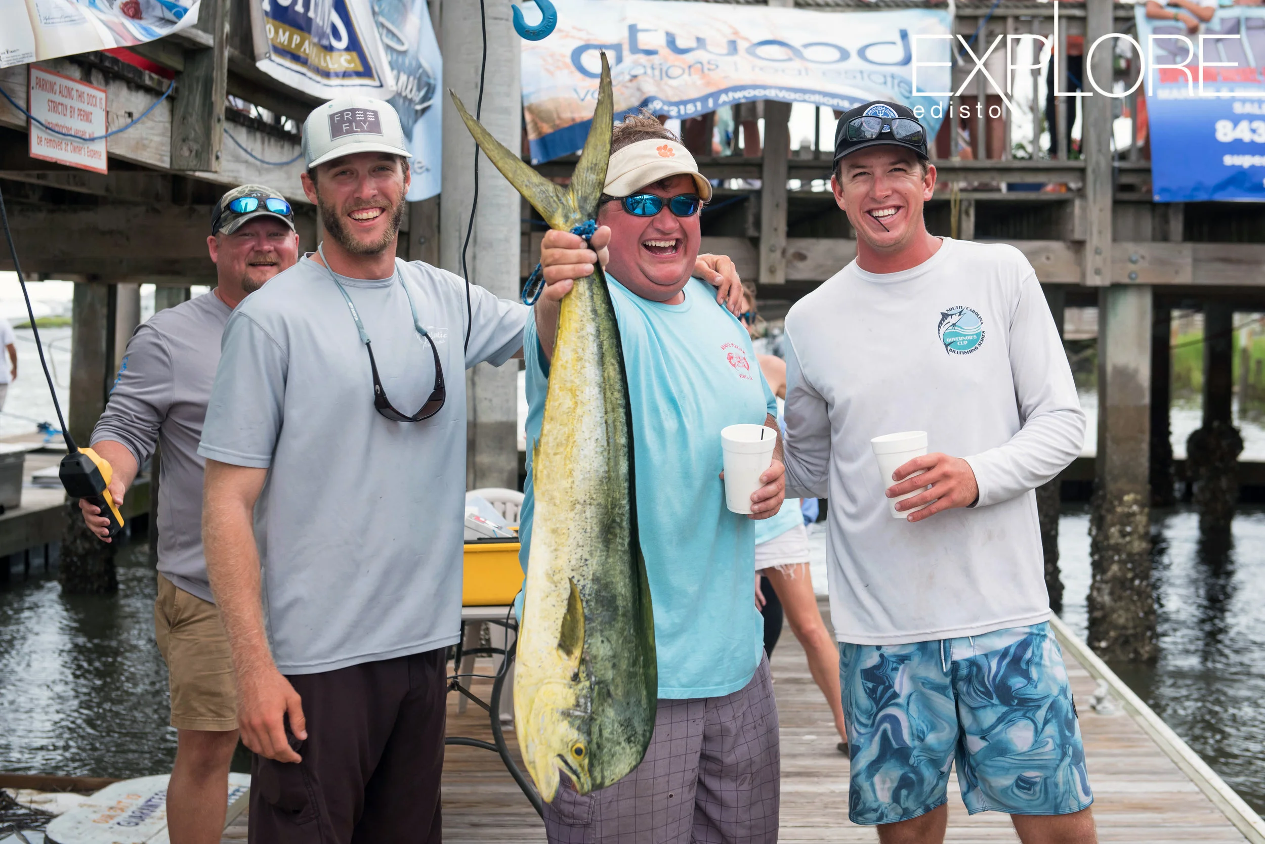 Fishermen pose with dolphin.
