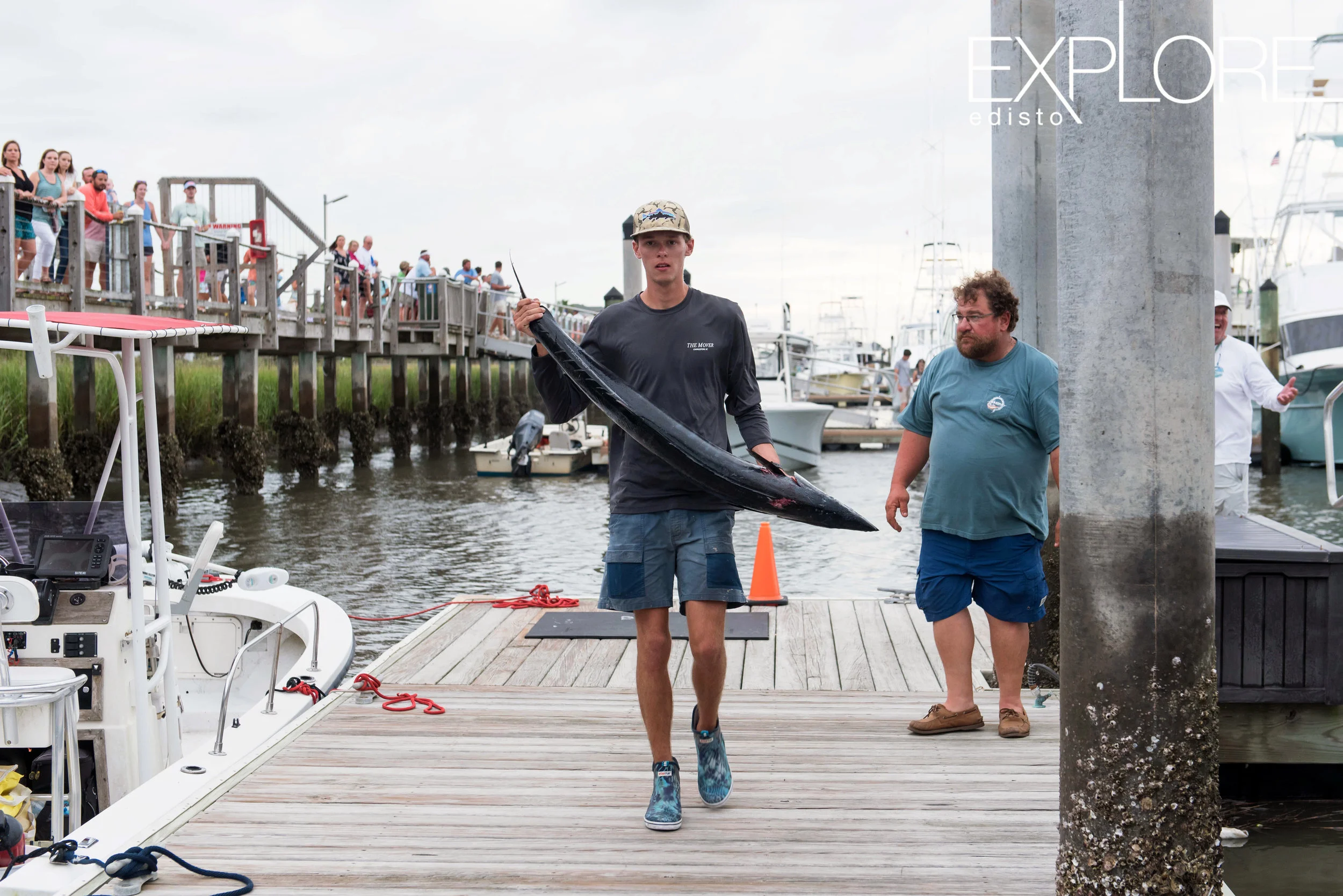 Fishermen carries wahoo to weigh-in.