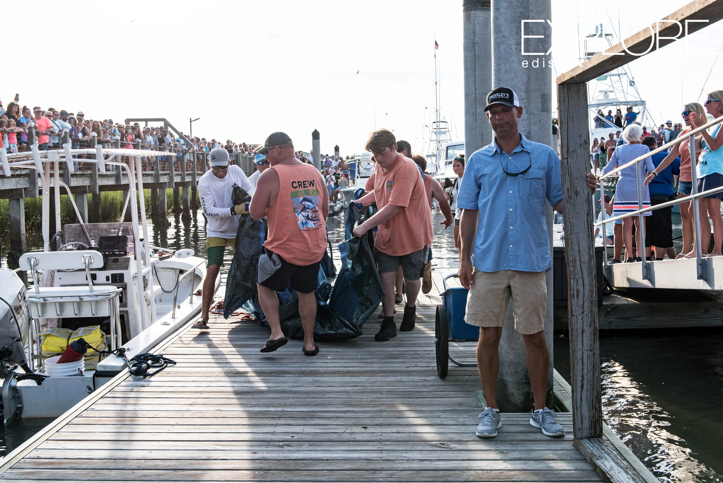 Men pull tarp with marlin down the dock to be weighed-in.