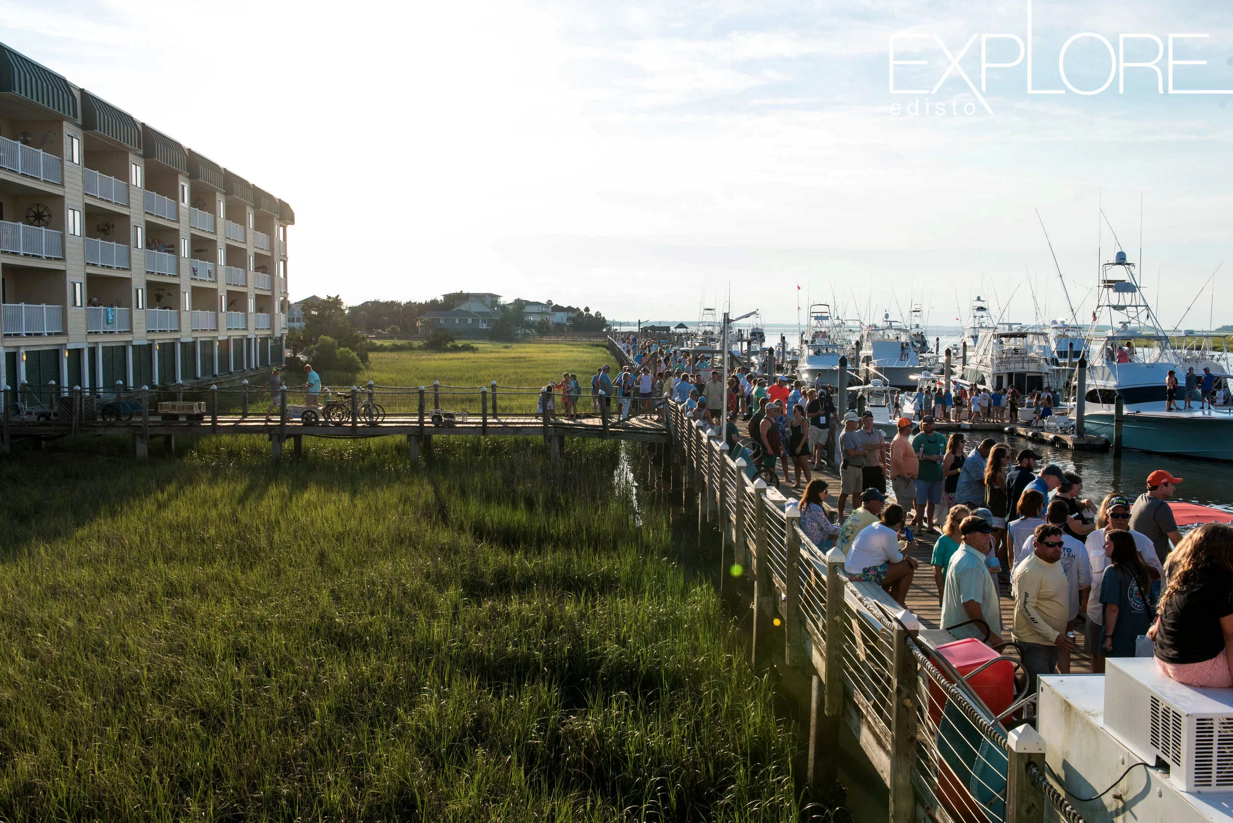 View of the marsh, docks and crowds of people at the Marina at Edisto Beach.