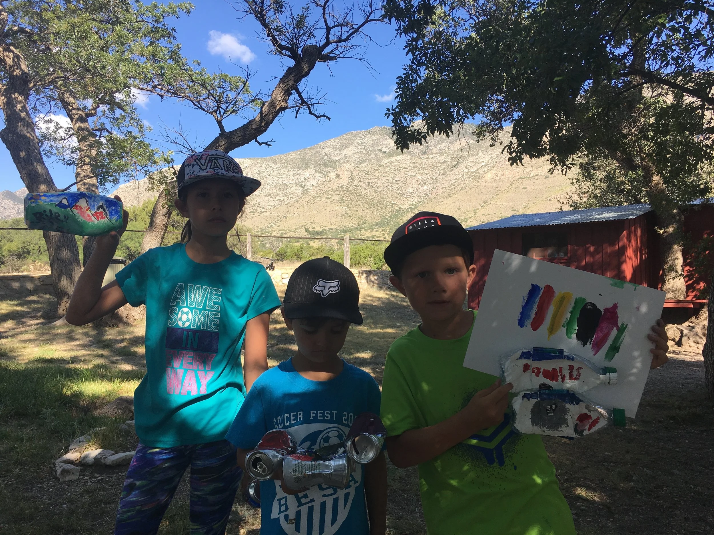 Three of the four siblings posing with their creations 