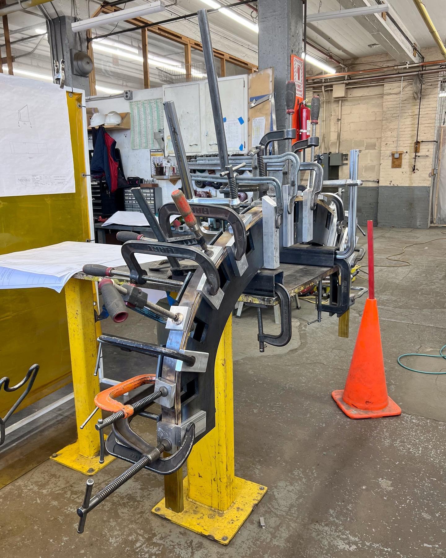 Here is that steel forming jig at work! Clamped onto it is one of two custom brass door arches that we&rsquo;re making. The arch in the second photo is post-forming.

#customdoor #customdoors #jig #metaljig #metalbending #metalforming #custommetal #c