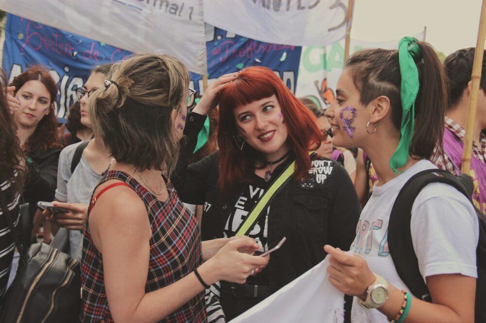  Young women consult about their looks while waiting for a march to begin. A lot of pleasure is taken in dressing in a way that both conveys their opposition to the law and suits their ideas of fun self-expression. 