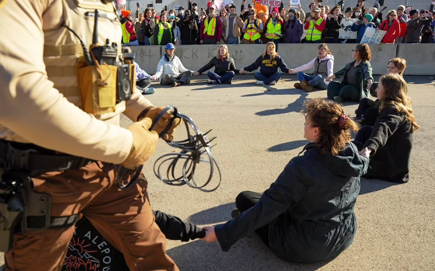 A group of self-identifying &quot;suburban moms&quot; took to the street outside the Broadview ICE facility this morning Nov 7th, holding space in the protest zone before jumping the barriers and sitting in a circle in the middle of the road and dema