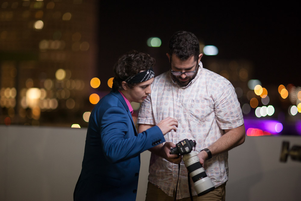 Deuce and Coleton reviewing images from their shoot in front of the Tampa Skyline