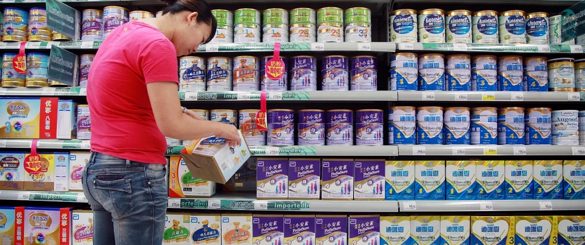 A customer selects baby milk in a supermarket in Haikou, south China’s Hainan province. Photo: STR/ AFP/ Getty Images.