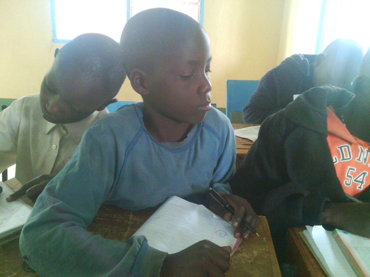 Fidel (center) loves studying math, and wants to be a doctor when he grows up. 