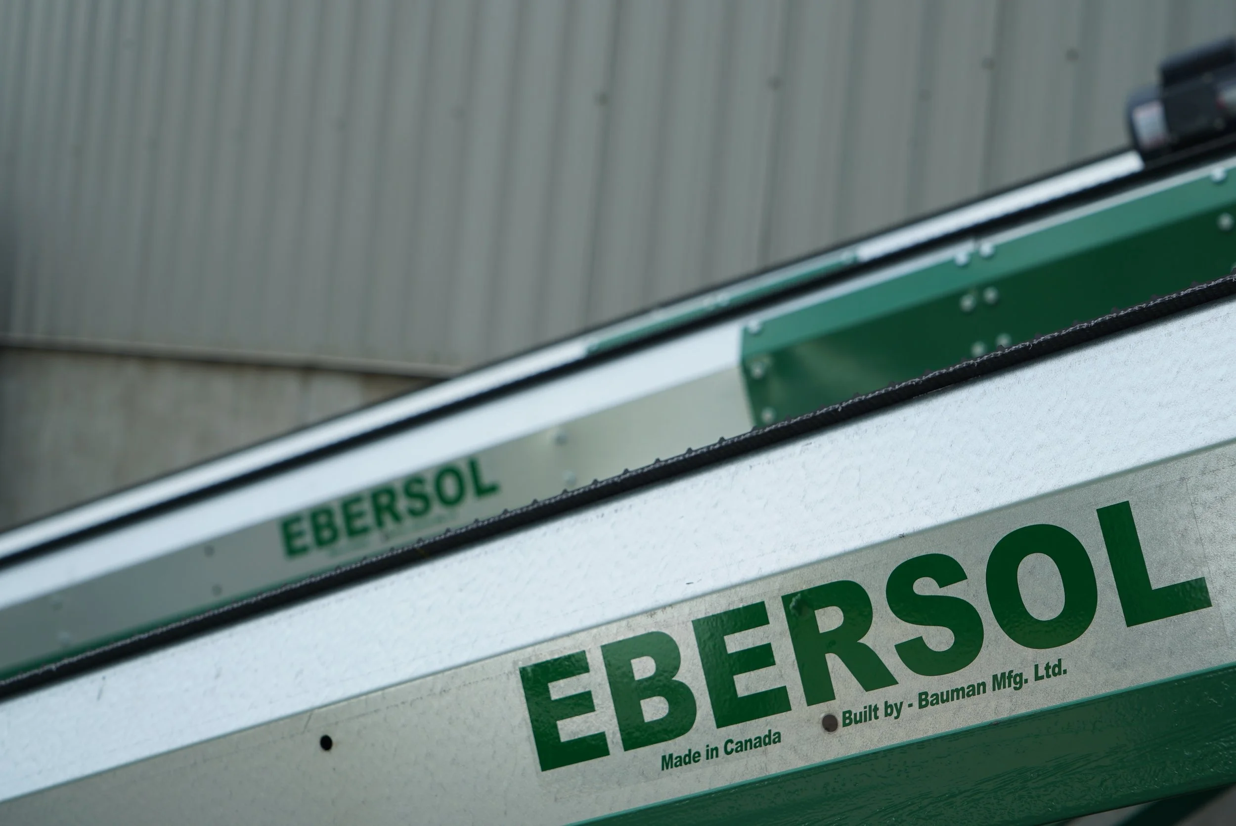 A close-up of Bauman's Ebersol Belt Conveyor decals, "Built by Bauman Manufacturing".